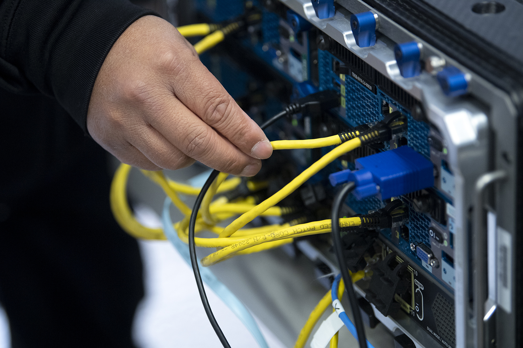 Technician checks a wire during a new computer network demonstration
