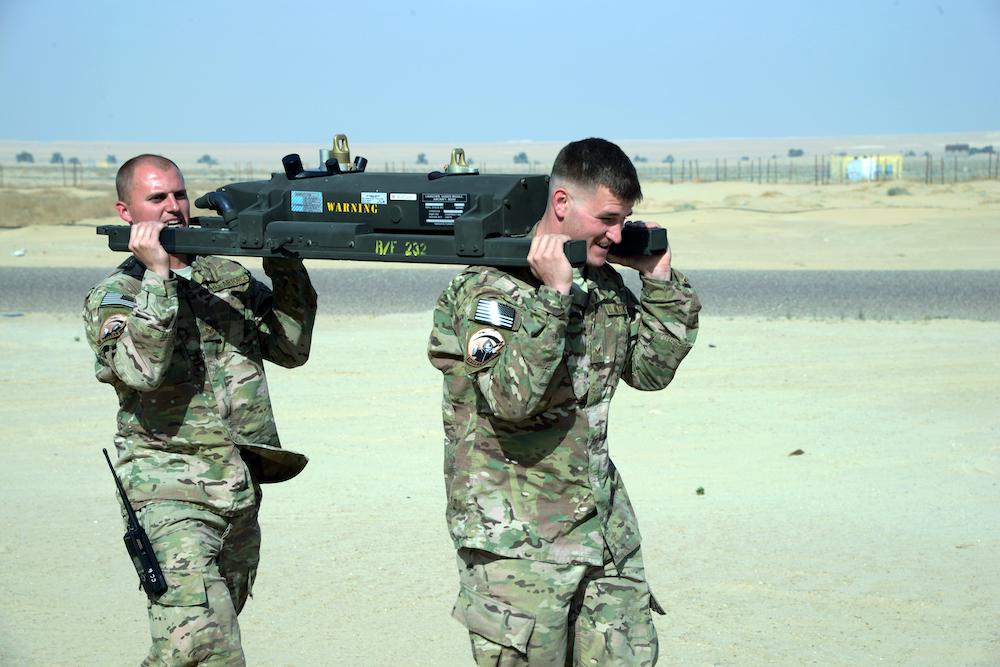 US Army soldiers transporting an M299 launcher rail to an MQ-9 Reaper