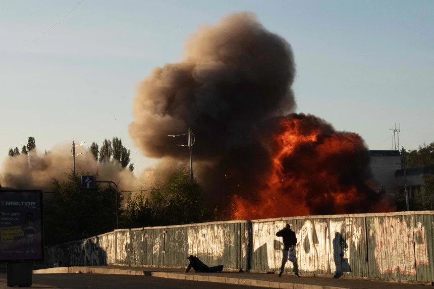A man falls to the ground following a drone attack in Kyiv