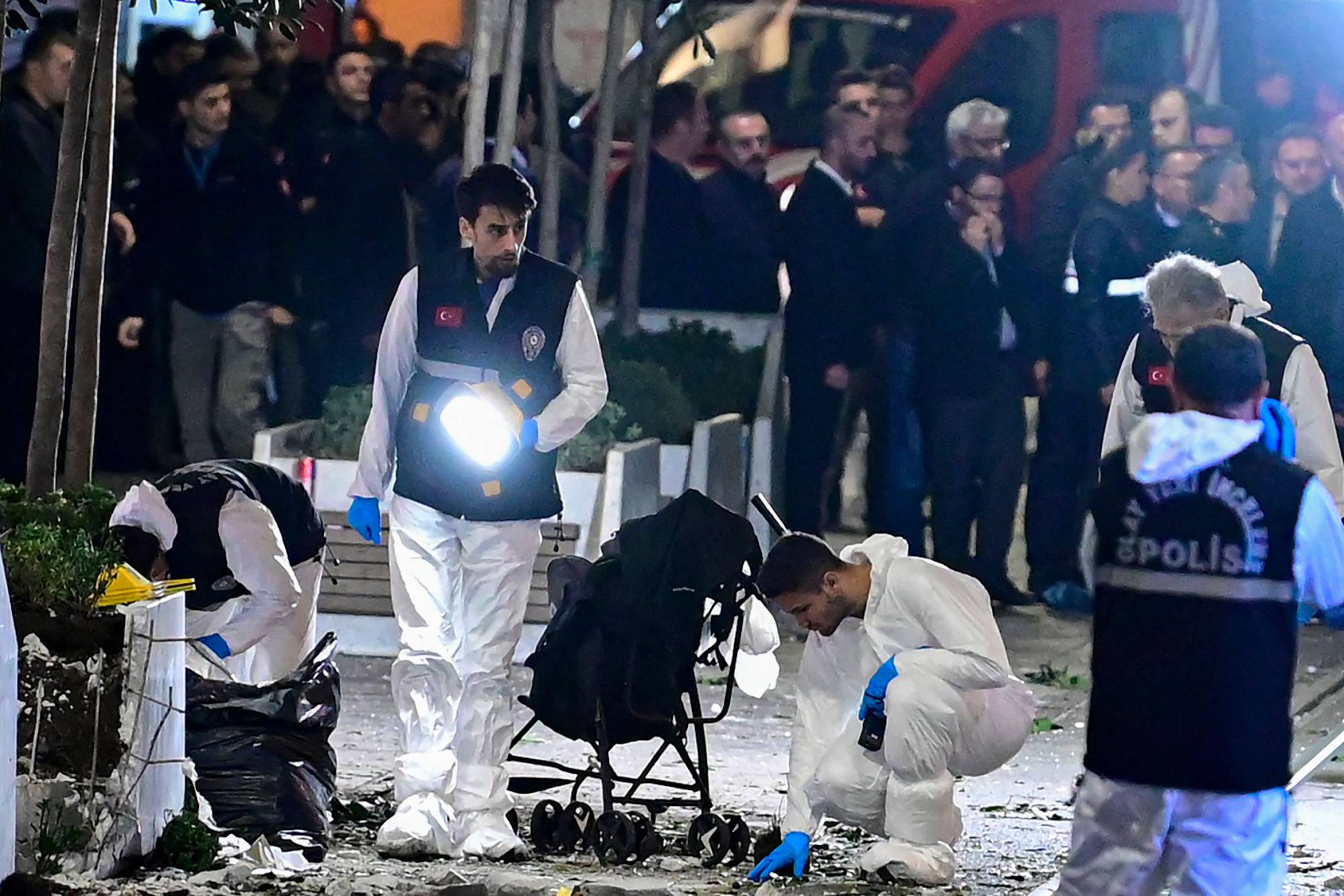 Investigators work after an explosion of unknown origin shook the busy shopping street of Istiklal in Istanbul