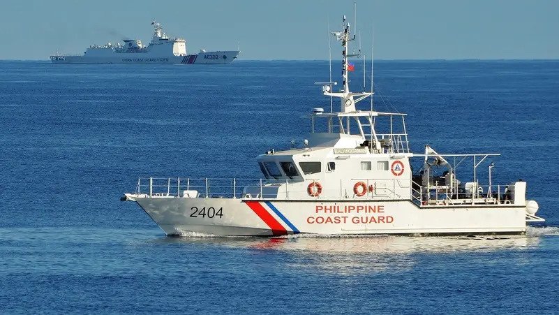 A Philippines' coast guard ship sailing past a Chinese coast guard ship during a joint search and rescue exercise between the Philippines and US coast guards near Scarborough Shoal in the South China Sea