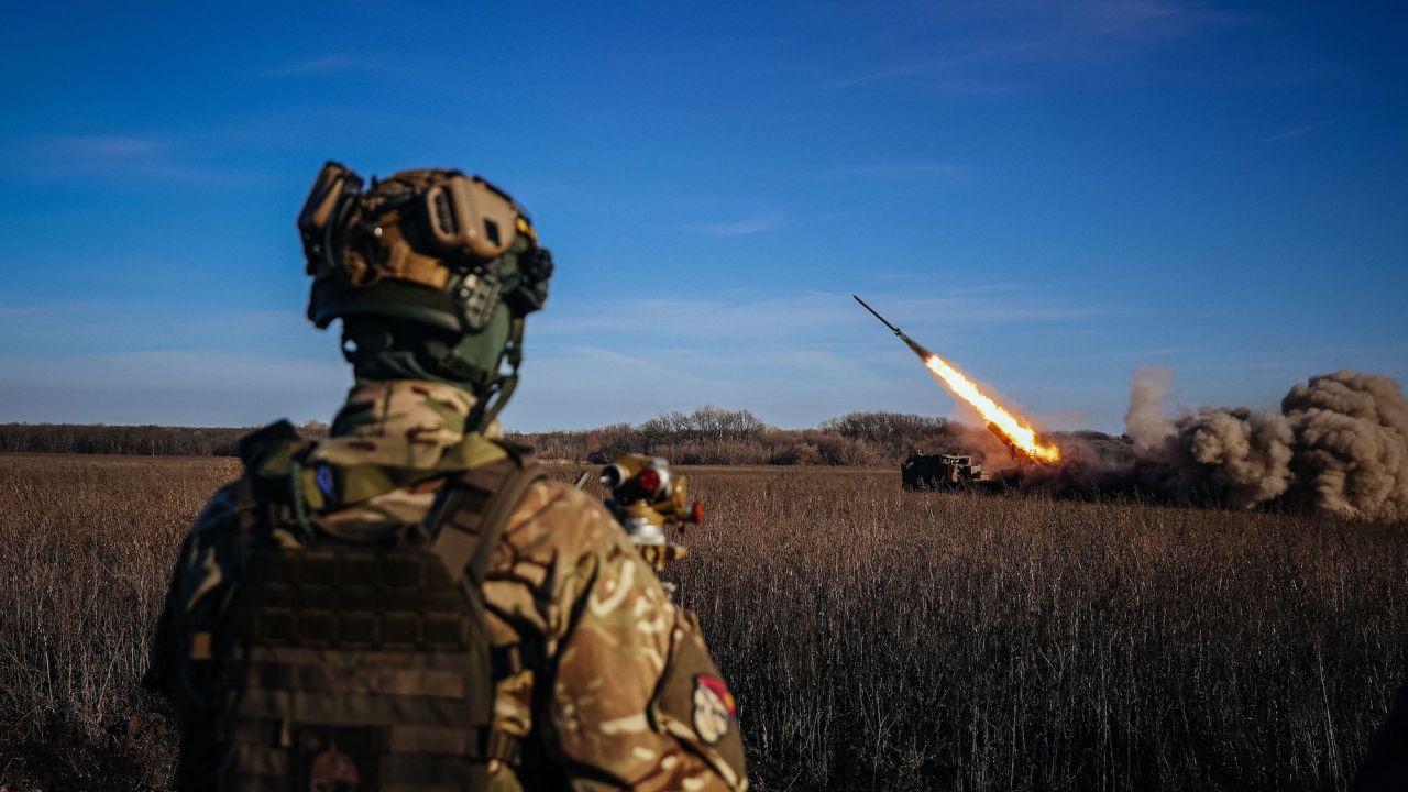 A Ukrainian soldier watches a self-propelled 220 mm multiple rocket launcher 