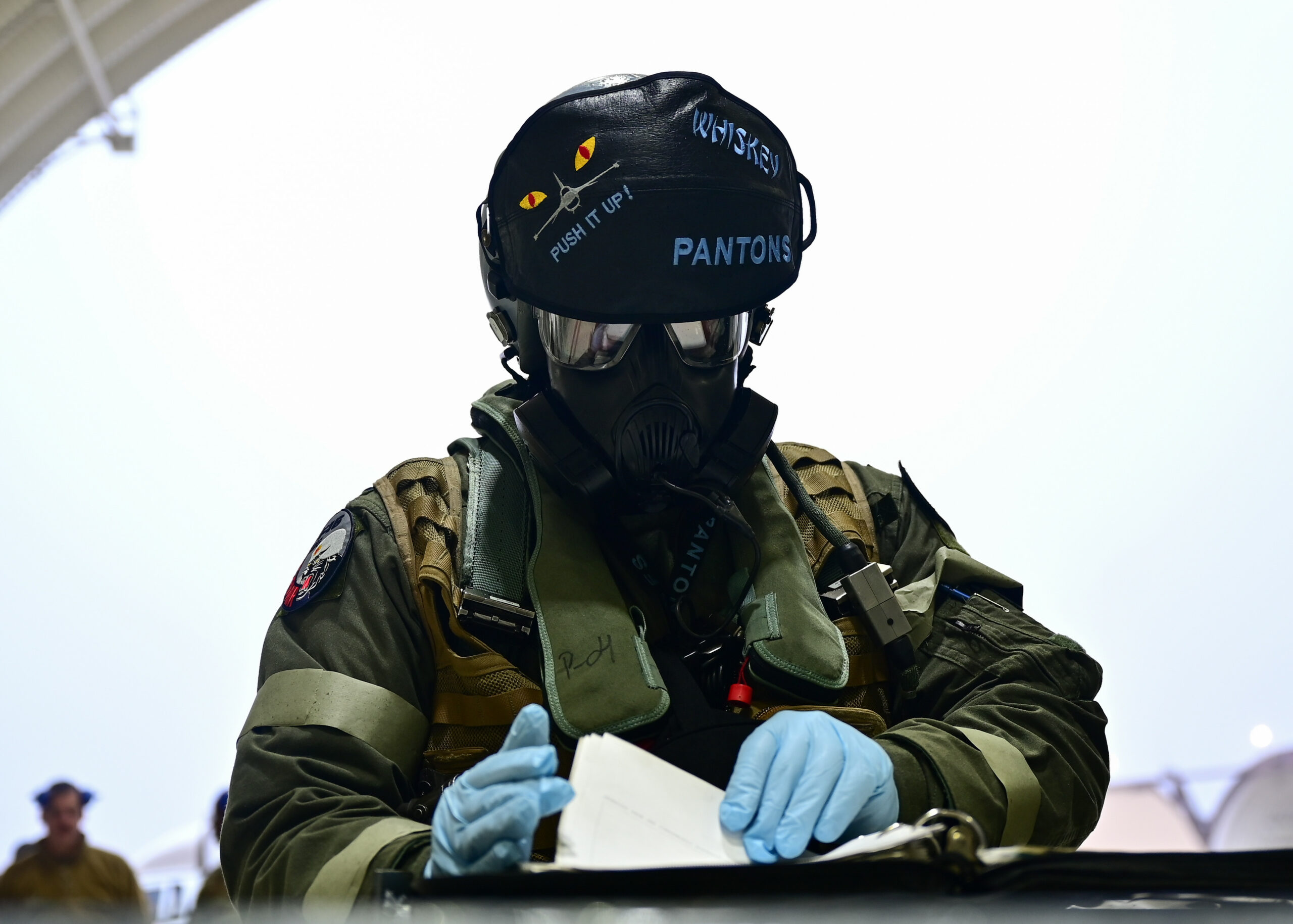 PACAF pilot prepares CBRN protective equipment at Kunsan Air Base, South Korea