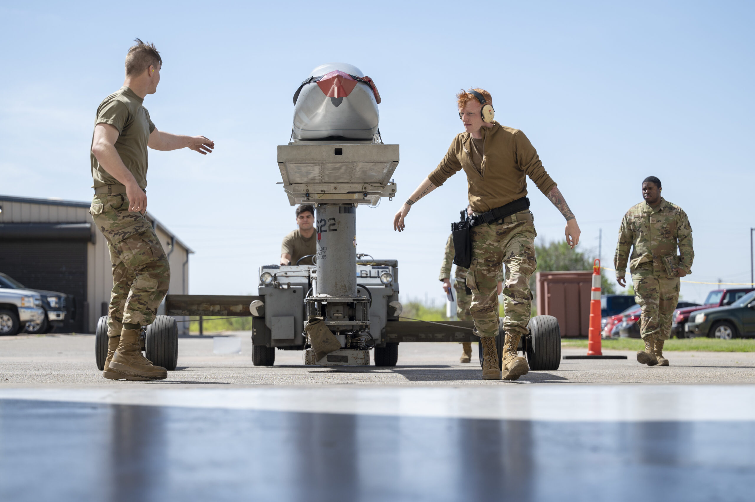 Weapons load crew members assigned to the 7th Aircraft Maintenance Unit transport an inert Joint Air-to-Surface Standoff Missile to a B-1B Lancer during a Load of the Quarter competition at Dyess Air Force Base, Texas, April 14, 2022. A JASSM is a conventional long-range standoff munition that offers weapons system officers the capability to engage various targets. (U.S. Air Force photo by Senior Airman Colin Hollowell)