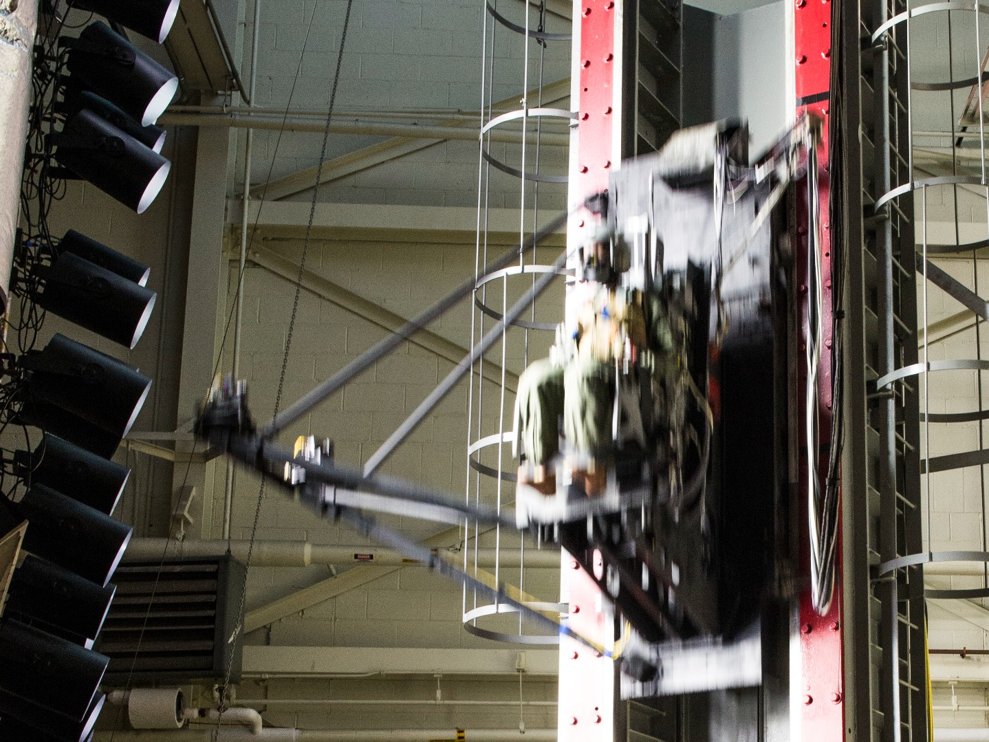 A test dummy equipped with a new modular handgun system is dropped at a rate of speed on a vertical deceleration tower inside the 711th Human Performance Wing, at Wright-Patterson Air Force Base, Ohio, Dec. 6, 2017. The drop is meant to simulate being ejected from an aircraft and tests the safety and durability of the new modular handgun system when exposed to the stresses associated with ejection from an aircraft. This is the first time any service has conducted this type of demonstration to ensure a side arm is safe for aircrew to carry in ejection seat aircraft. (U.S. Air Force photo by Wesley Farnsworth)