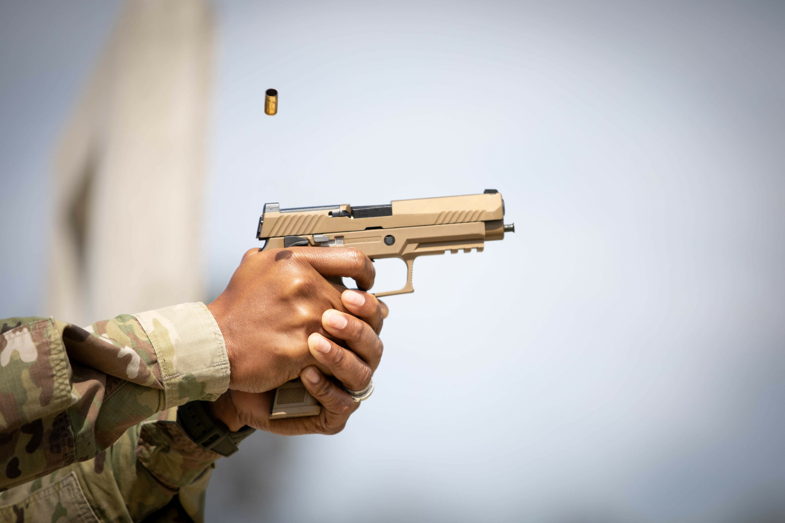 A cartridge exits the chamber after being fired from a SIG Sauer P320-M17, semi-automatic pistol during the Contract Operational Readiness Exercise (CORE) M17 qualifications at Camp Bullis in San Antonio, Texas, April 19, 2021. The CORE-21 serves as culminating events for Soldiers set to deploy within the coming months and next fiscal year. (U.S. Army photo by Spc. Eric Kestner / Released by Ms. Angele Ringo 377th Public Affairs Specialist).