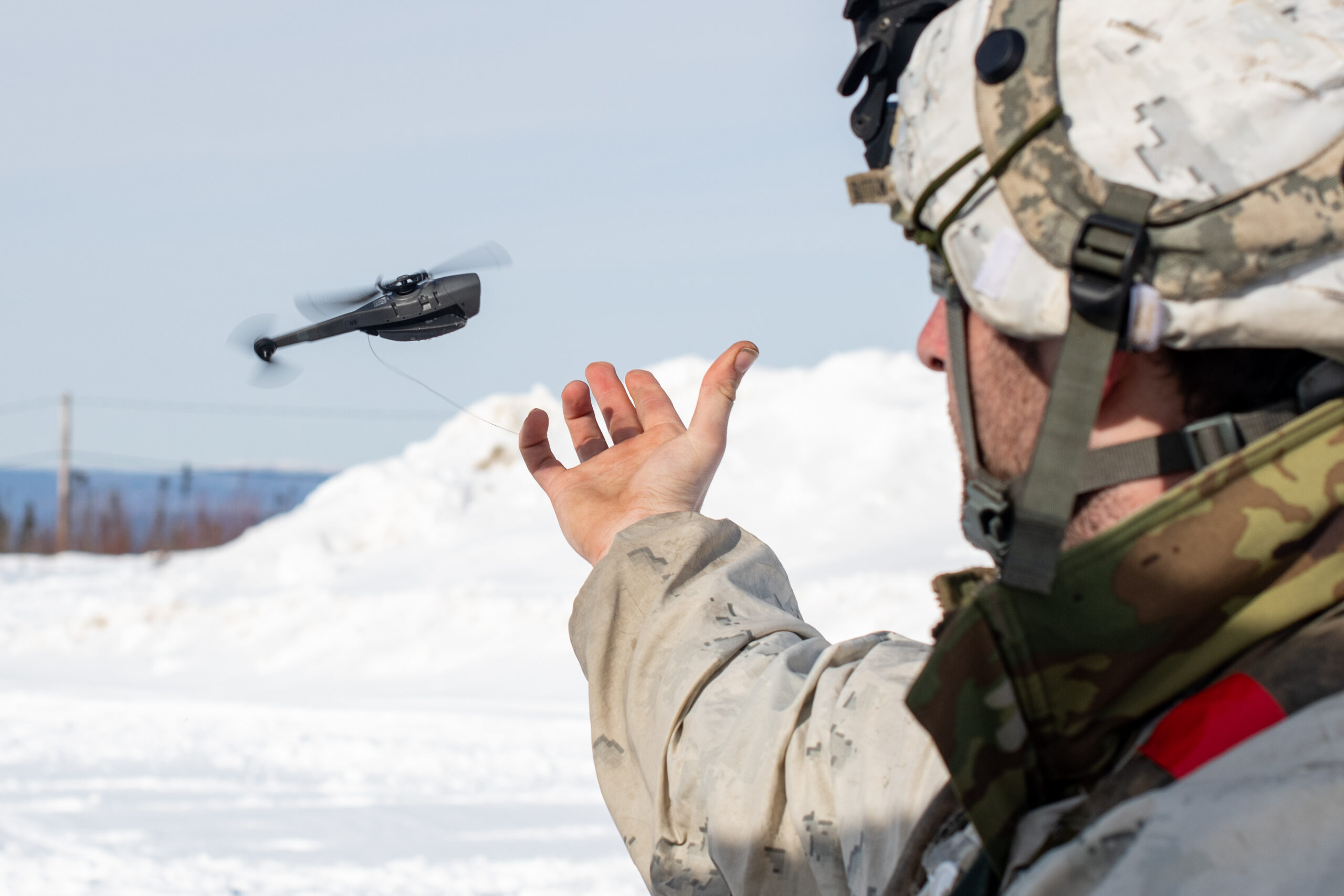 U.S. Army Sgt. Nicholas Sutton, an infantryman assigned to the 1st Battalion, 5th Infantry Regiment, 1st Infantry Brigade Combat team, 11th Airborne Division, releases a Black Hornet 3 drone at a remote fighting position during Joint Pacific Multinational Readiness Center-Alaska 23-02 at Yukon Training Area, Alaska, April 3, 2023. JPMRC-AK 23-02, executed in Alaska with its world-class training facilities and its harsh Arctic environment, builds Soldiers and leaders into a cohesive team of skilled, tough, alert, and adaptive warriors capable of fighting and winning anywhere. (U.S. Air Force photo by Senior Airman Patrick Sullivan)