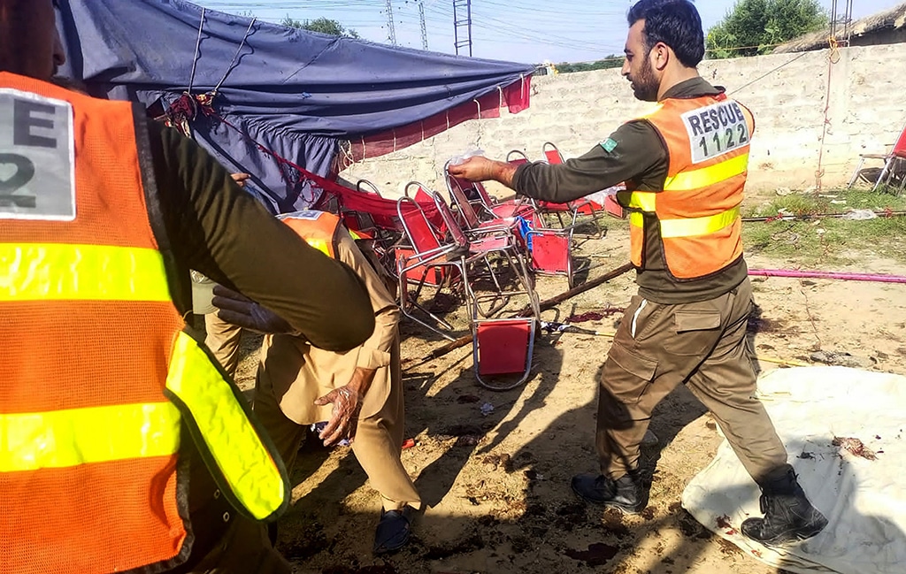 Rescue workers inspect the site after a suicide blast in Pakistan's Khyber Pakhtunkhwa province on July 30, 2023