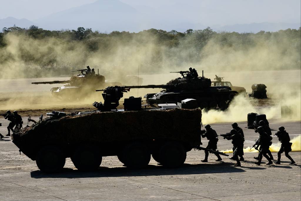 Taiwanese soldiers stay behind armed vehicles during a drill at the Hsinchu military base in 2021
