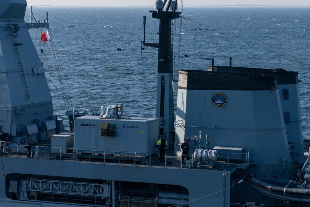 Part of the upper deck of Germany's Sachsen F-124 ship is seen on the photo. the laser weapon demonstrator, which looks like a giant rectangular box, is seen on the center left. The initials 