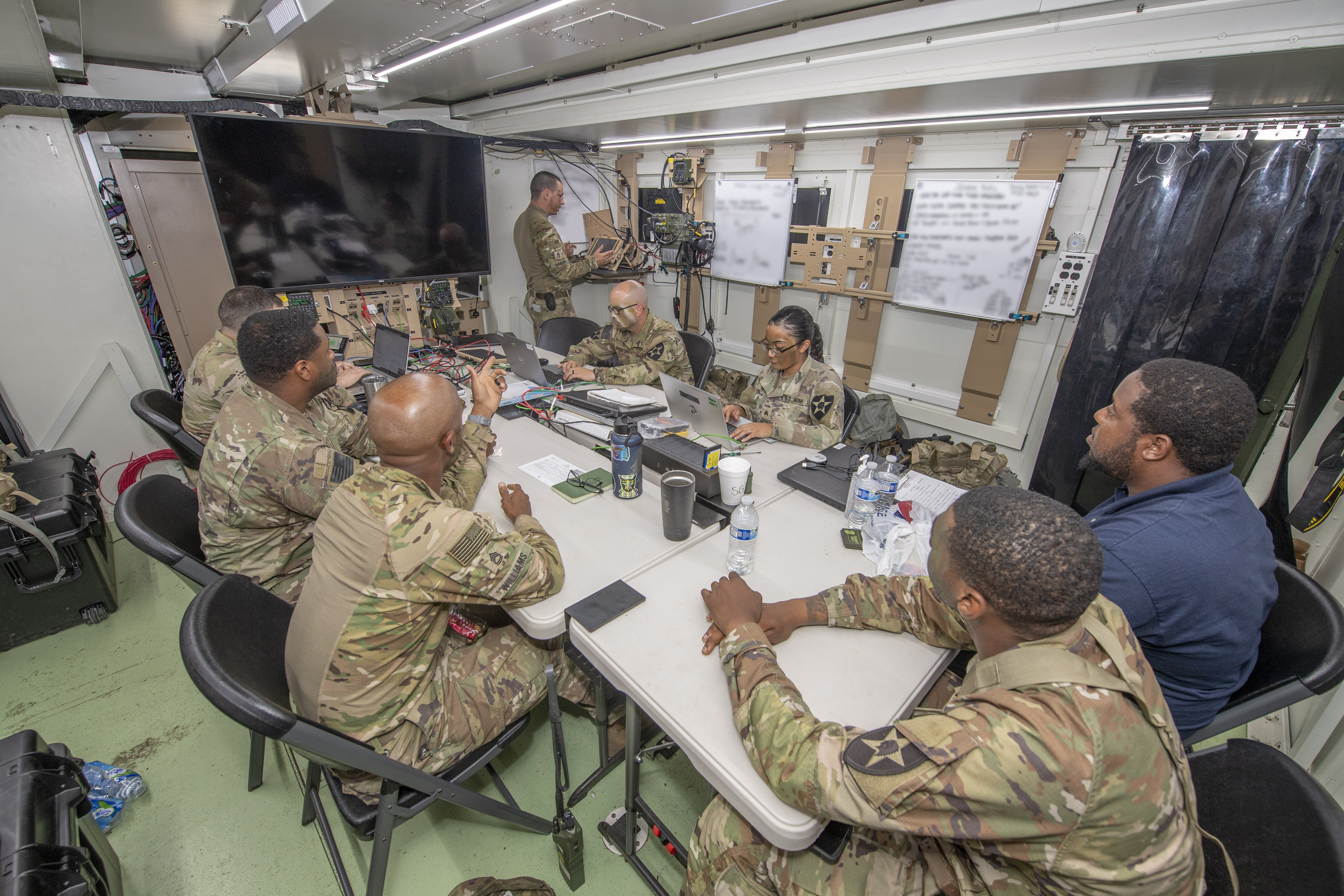Communication Soldiers of the 1st Stryker Brigade Combat Team “Ghost,” 2nd Infantry Division, work out of the brigade’s tactical action center — “expando” vehicle — with quick connection capabilities to establish battlefield communications. (U.S. Army photo by Tad Browning) 