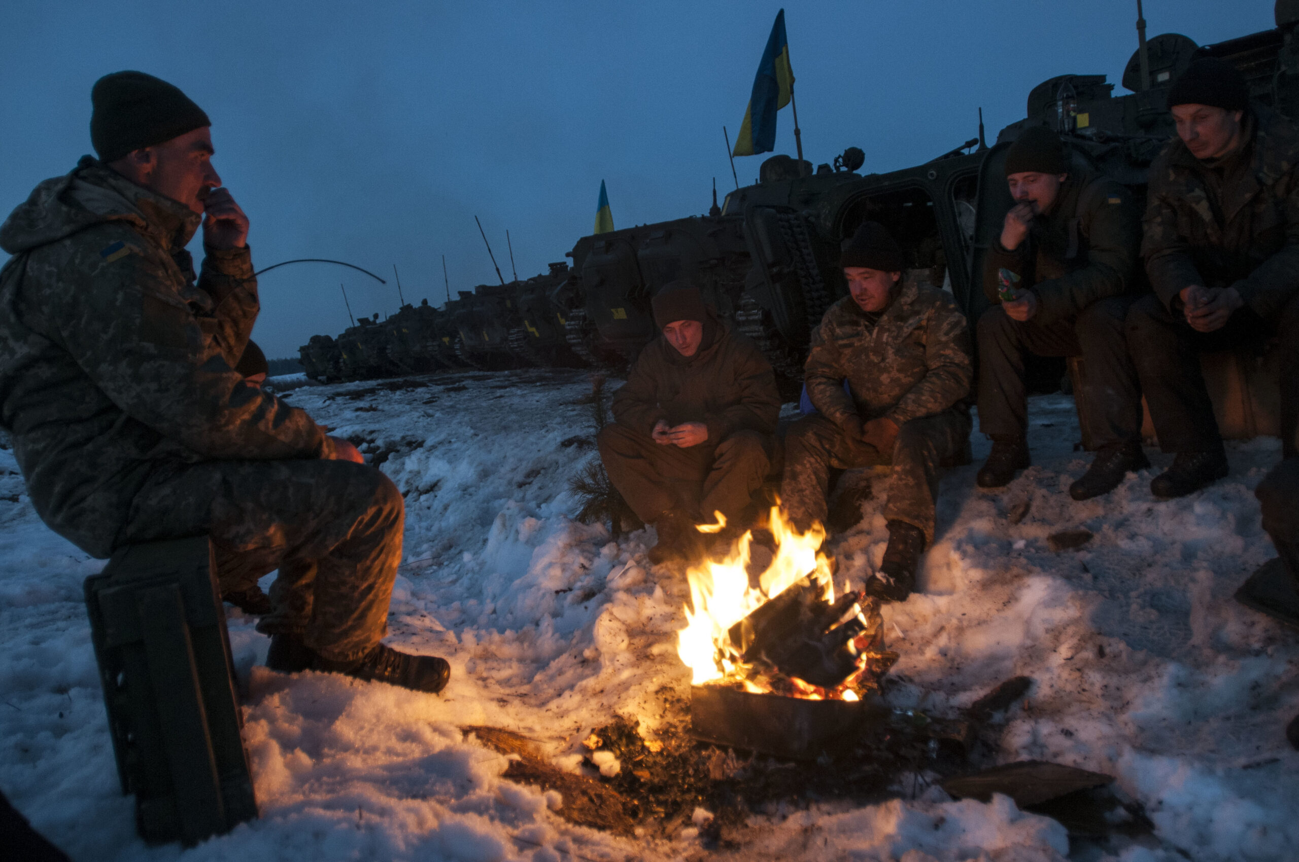 Crew members of a Ukrainian BMP-2 armored vehicle warm themselves by a fire before returning to the firing line for a night fire exercise at the International Peacekeeping and Security Center, near Yavoriv, Ukraine, on Feb. 16. (Photo by Sgt. Anthony Jones, 45th Infantry Brigade Combat Team)