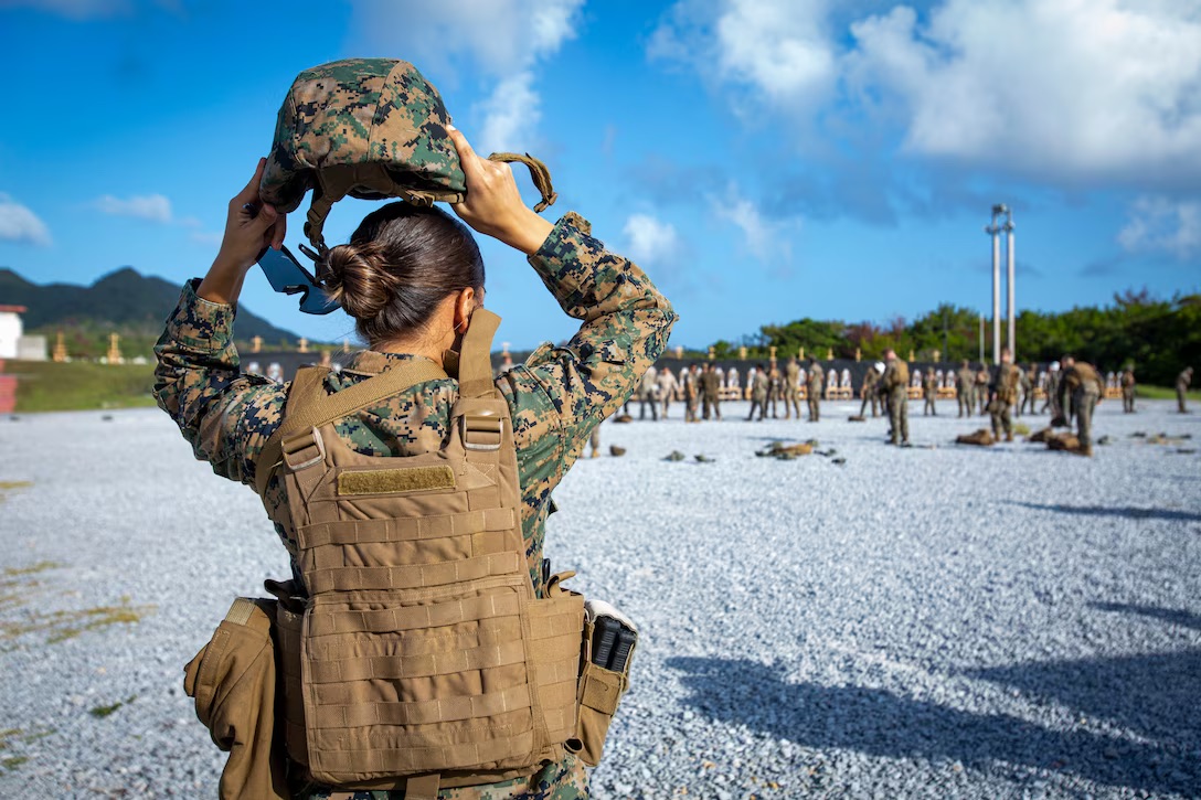 US Marine Corps Sergeant places on a kevlar.