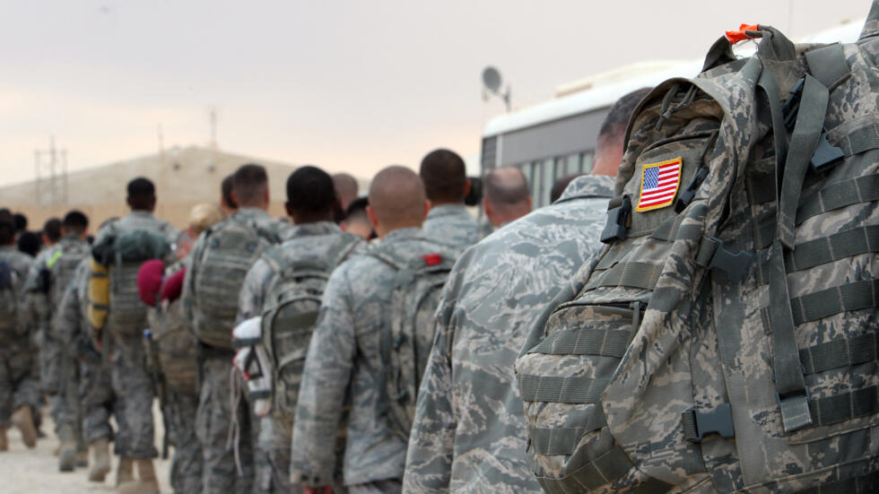US army soldiers queue to board a plane to begin their journey home out of Iraq from the al-Asad Air Base west the capital Baghdad, November 1, 2011.