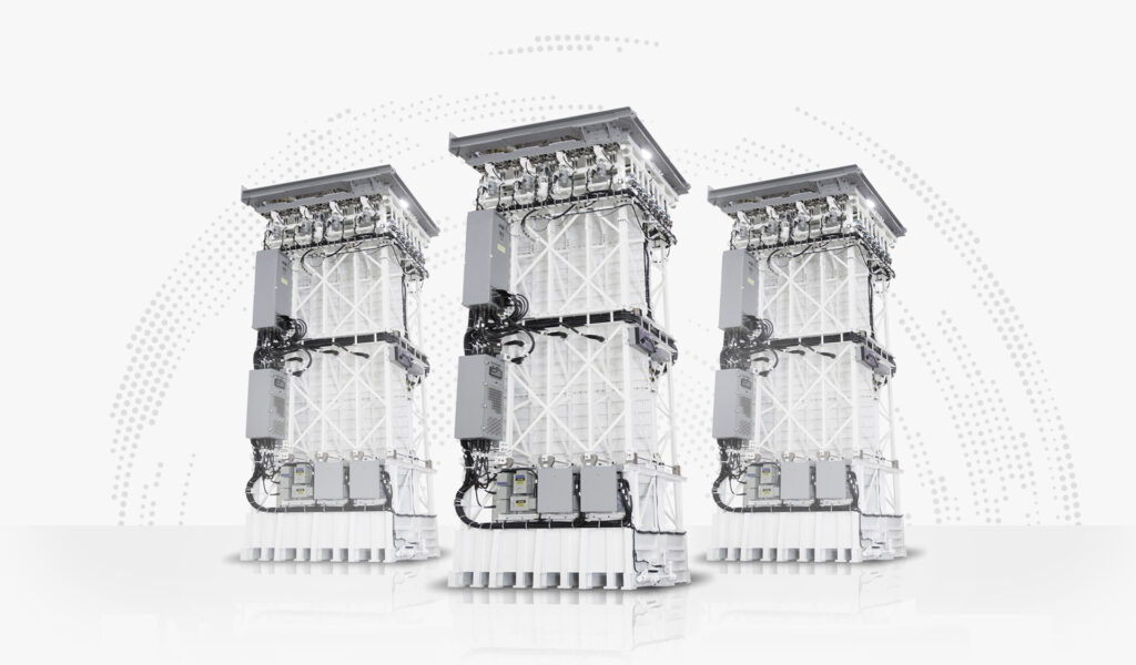 Three MK 41 Vertical Launch Systems are on display. The capability is a tall, tower-shaped equipment with supportive beams and wires fitted onto it. Most of its body is painted white.