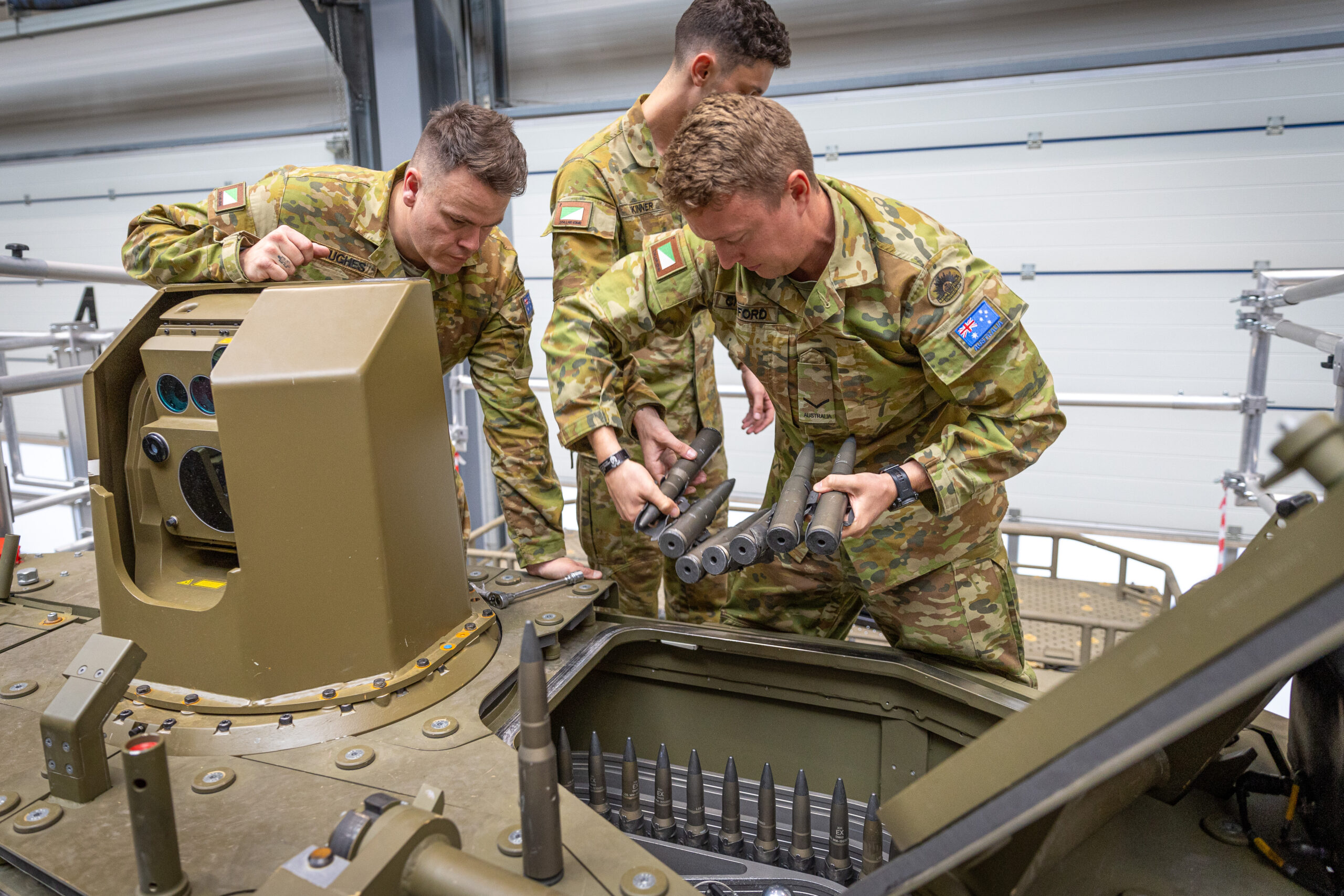 SGT Chris Hughes, LCPL Ben Crawford and TPR Liam Skinner reload the 30mm ammunition magazine on the Boxer Combat Reconnaissance Vehicle. *** Local Caption *** Testing of the Boxer Combat Reconnaissance Vehicle was recently undertaken in Germany, by members of CASG Land Domain and 2/14 LHR (QMI). Tests included firing the MK30-2 cannon and MAG58 machine gun in extreme weather conditions, as well as testing the new programmable munitions capability. Three soldiers from 2/14 LHR (QMI) were involved in testing at the Rheinmetall site in Unterluss, Germany, where the vehicles Lance 2.0 turret was designed and initial production has commenced. The visit included a brief on the Block II vehicle design, operation of the Combat Intelligence, Surveillance and Reconnaissance system and new weapon control systems. Development of these systems included input from 2/14 LHR soldiers, leveraging their experience with the Block I vehicles.