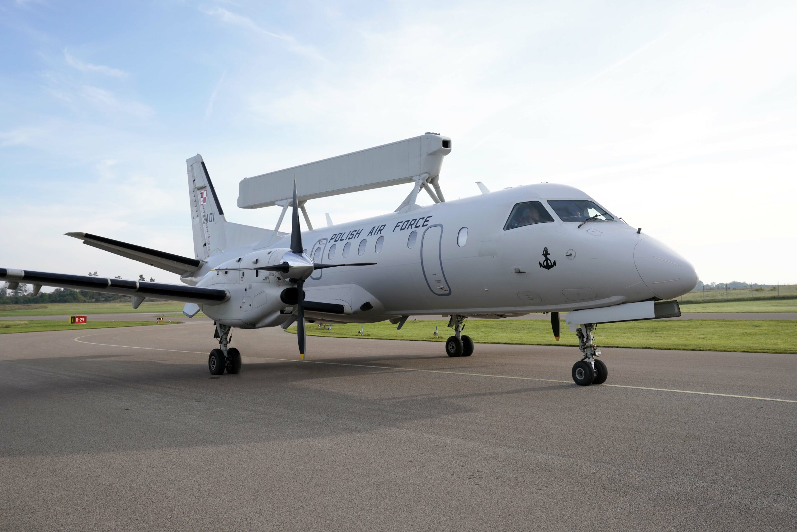 Poland's Saab 340 Airborne Early Warning (AEW) aircraft is seen on a runway. The plane is white and has 