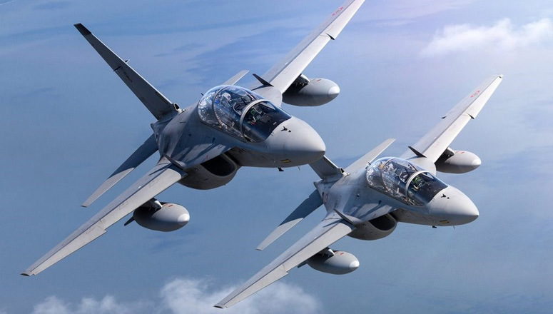 Two fighter planes fly above the clouds.