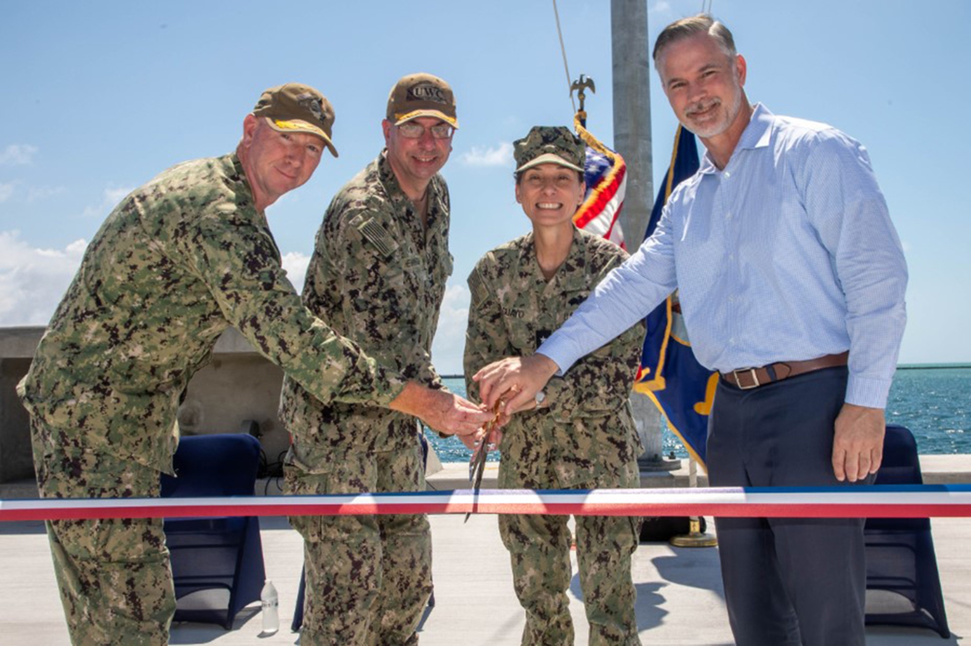Naval Undersea Warfare Center Division Newport Commanding Officer Capt. Chad Hennings (second from left) is joined by Cmdr. Jeremy Reed (from left), officer in charge at the Atlantic Undersea Test and Evaluation Center (AUTEC), Rear Adm. Lore Aguayo, commander of the Naval Facilities Engineering Systems Command Atlantic, and Rick Quade, deputy for Test and Evaluation for the Department of the Navy, for a ribbon-cutting ceremony to mark the reopening of Pier 1902 at AUTEC, a Division Newport detachment, on May 8, 2024. AUTEC recently completed two other projects — upgrades to the Entry Control Facility at the main gate and construction of a $30.2 million two-story housing complex for 174 military personnel.