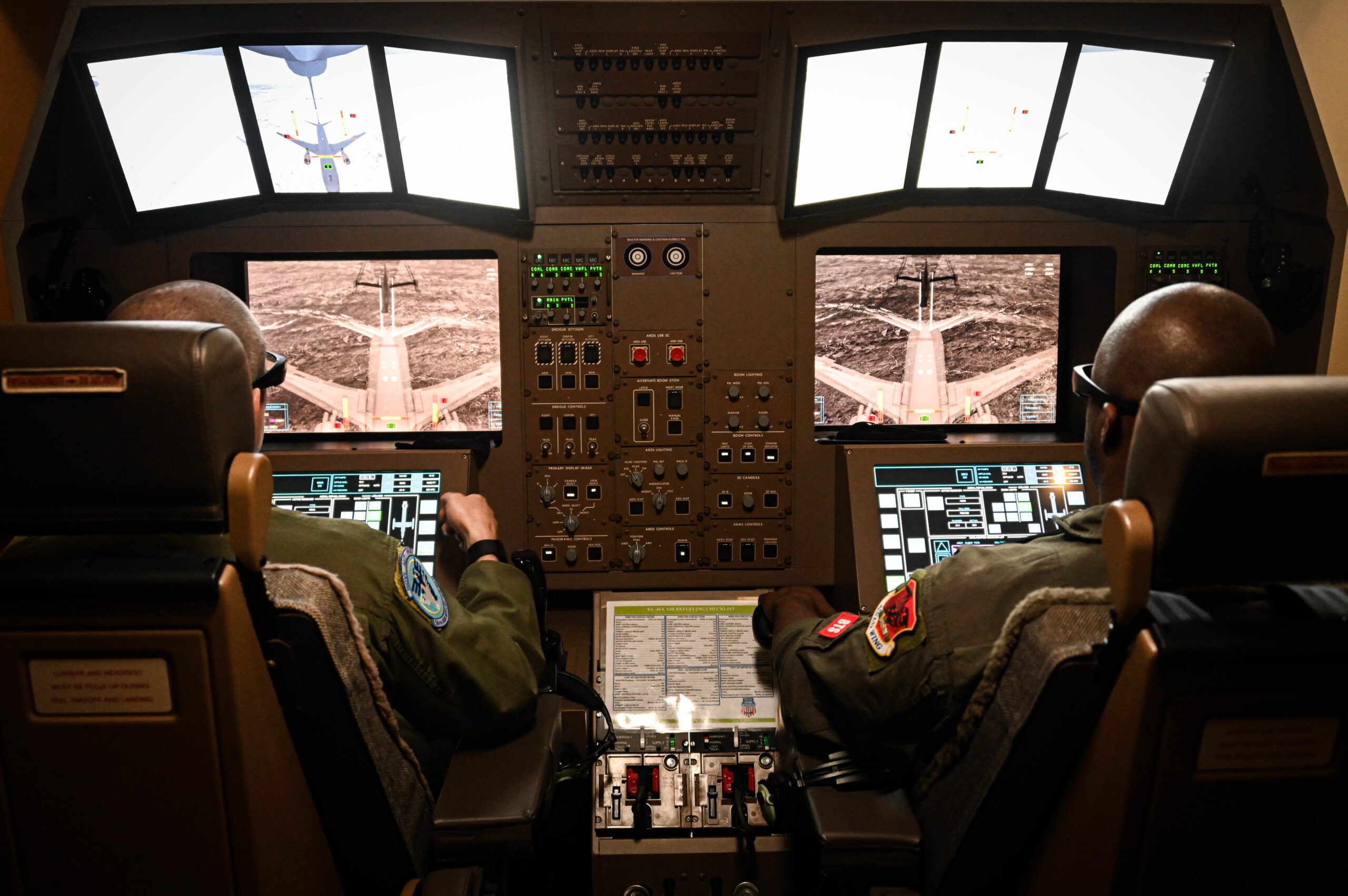 U.S. Air Force Master Sgt. Joseph Vondohlen (left), 54th Air Refueling Squadron boom operator instructor, and Tech. Sgt. Marcus, 432nd Air Expeditionary Wing evaluator sensor operator, practice in-flight air refueling in a Boom Operator Training (BOT) simulator at Altus Air Force Base, Oklahoma, March 9, 2022. BOT is a new simulation system the 97th Air Mobility Wing uses to train boom operators to refuel from the KC-46 Pegasus. (U.S. Air Force photo by Senior Airman Kayla Christenson)