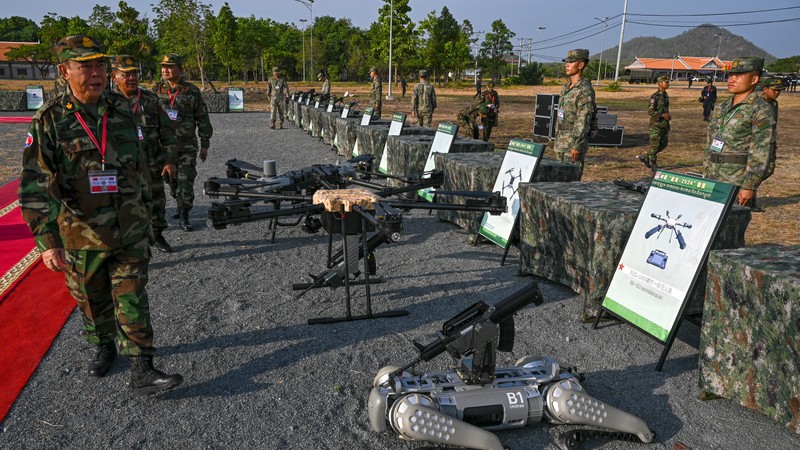 Cambodian Armed Forces commanders inspect drones and a machine gun equipped robot battle 