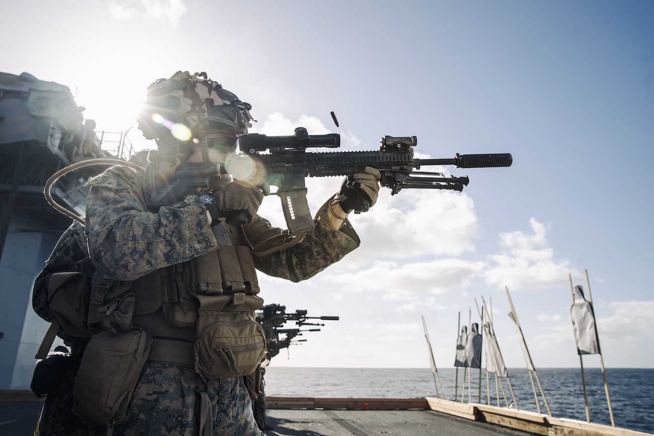 US Marine Corps Lance Cpl. fires an M27 Infantry Automatic Rifle during a live-fire deck shoot