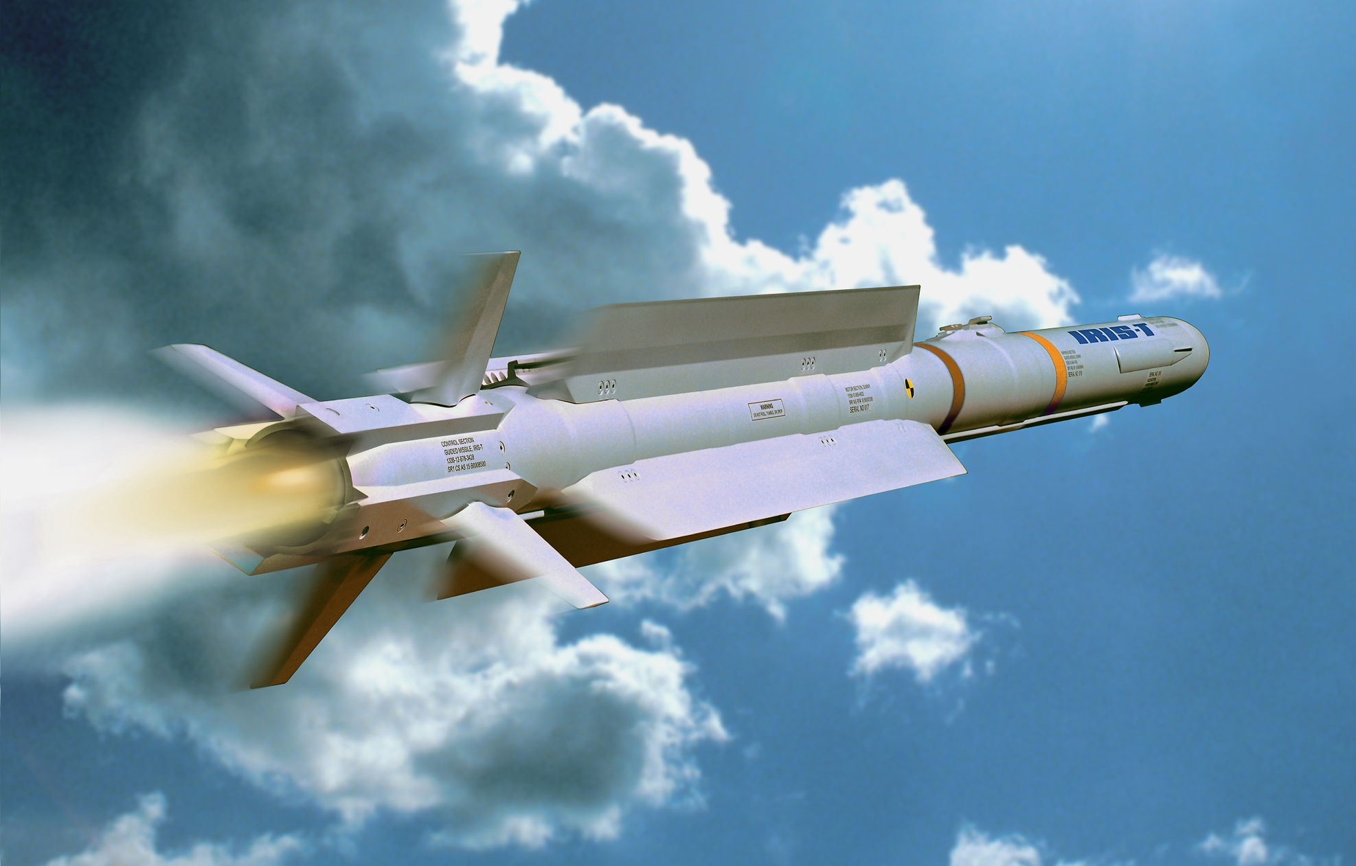 An IRIS-T missile is seen flying in a cloudy blue sky. It juts out smoke and red and white flames as it propels upward. The missile is sleek, painted gray, and has four fins attached to its bottom.