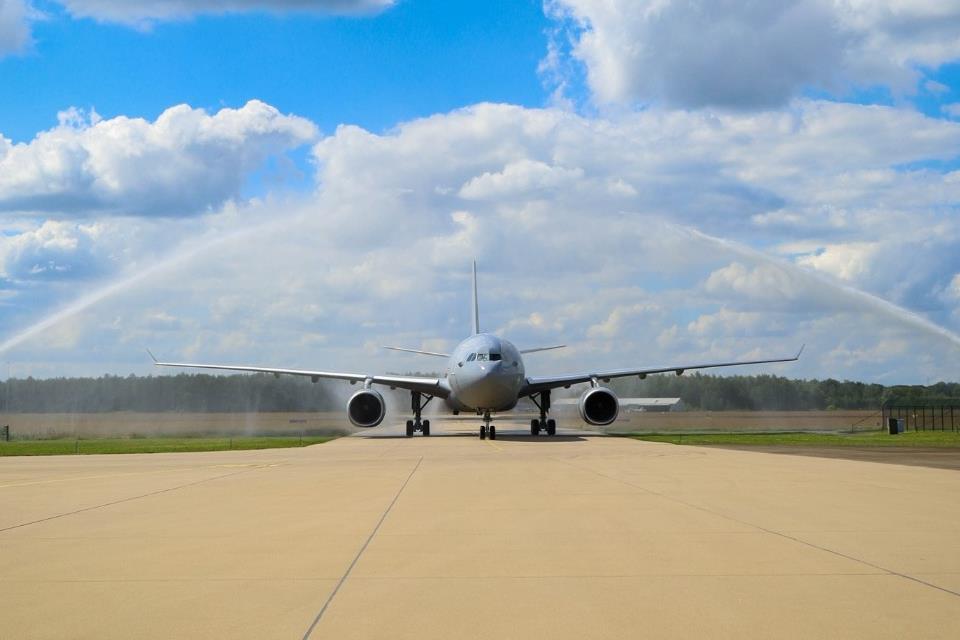 The A330 MRTT T-061 aircraft is welcomed at the MMU Main Operating Base at the traditional water arch. The plane is facing frontward.