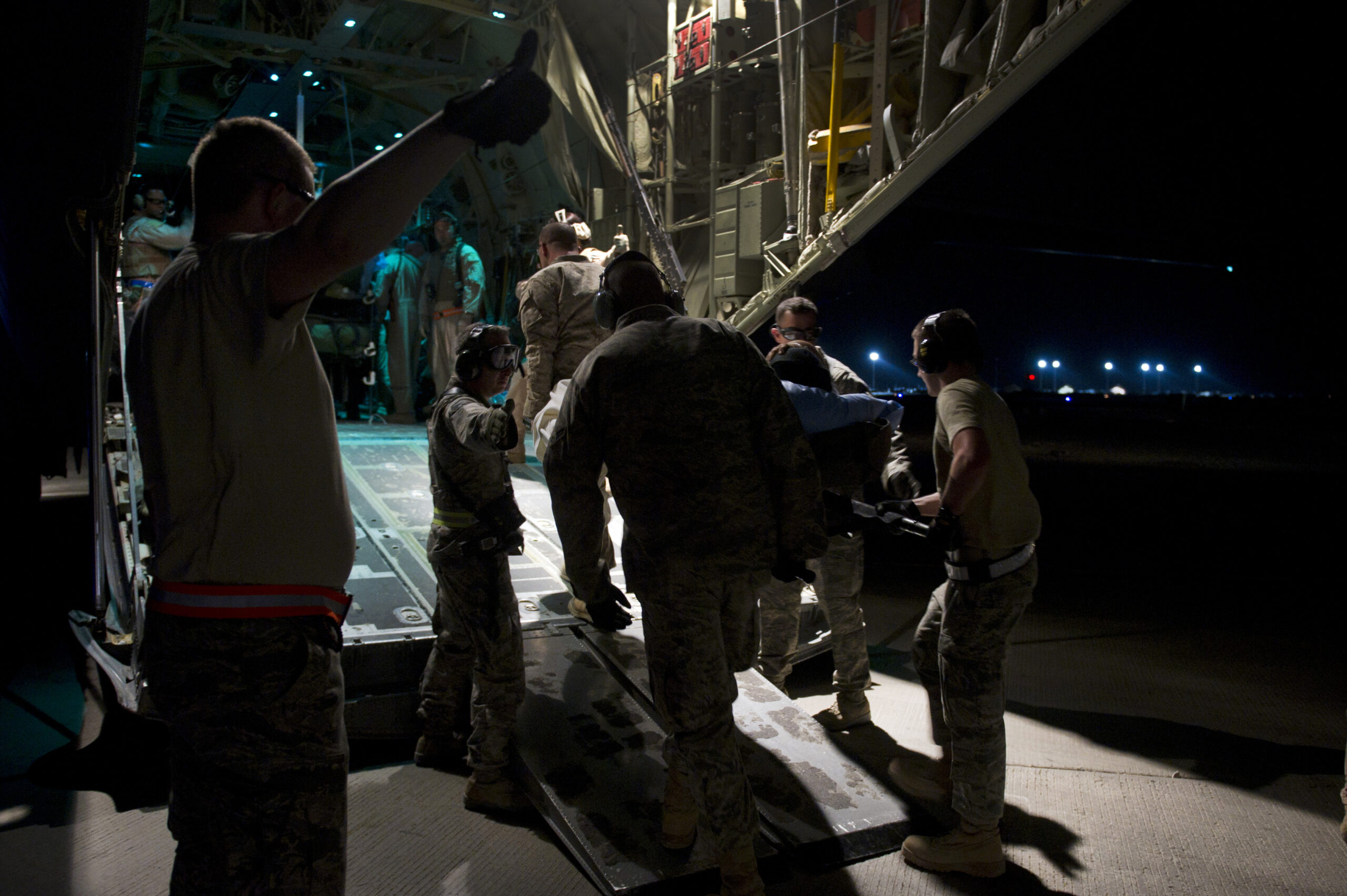 Members from the 451st Expeditionary Aeromedical Evacuation Squadron Detachment 1 Contingency Aeromedical Staging Facility load a wounded Marine off an ambulance bus onto a C-130 Hercules at Camp Bastion, Afghanistan. The CASF team is responsible for taking care of patients and transporting them from the staging facility and hospital to a waiting aircraft who are then taken to the next level of medical care. (U.S. Air Force photo/Master Sgt. Adrian Cadiz)(Released)