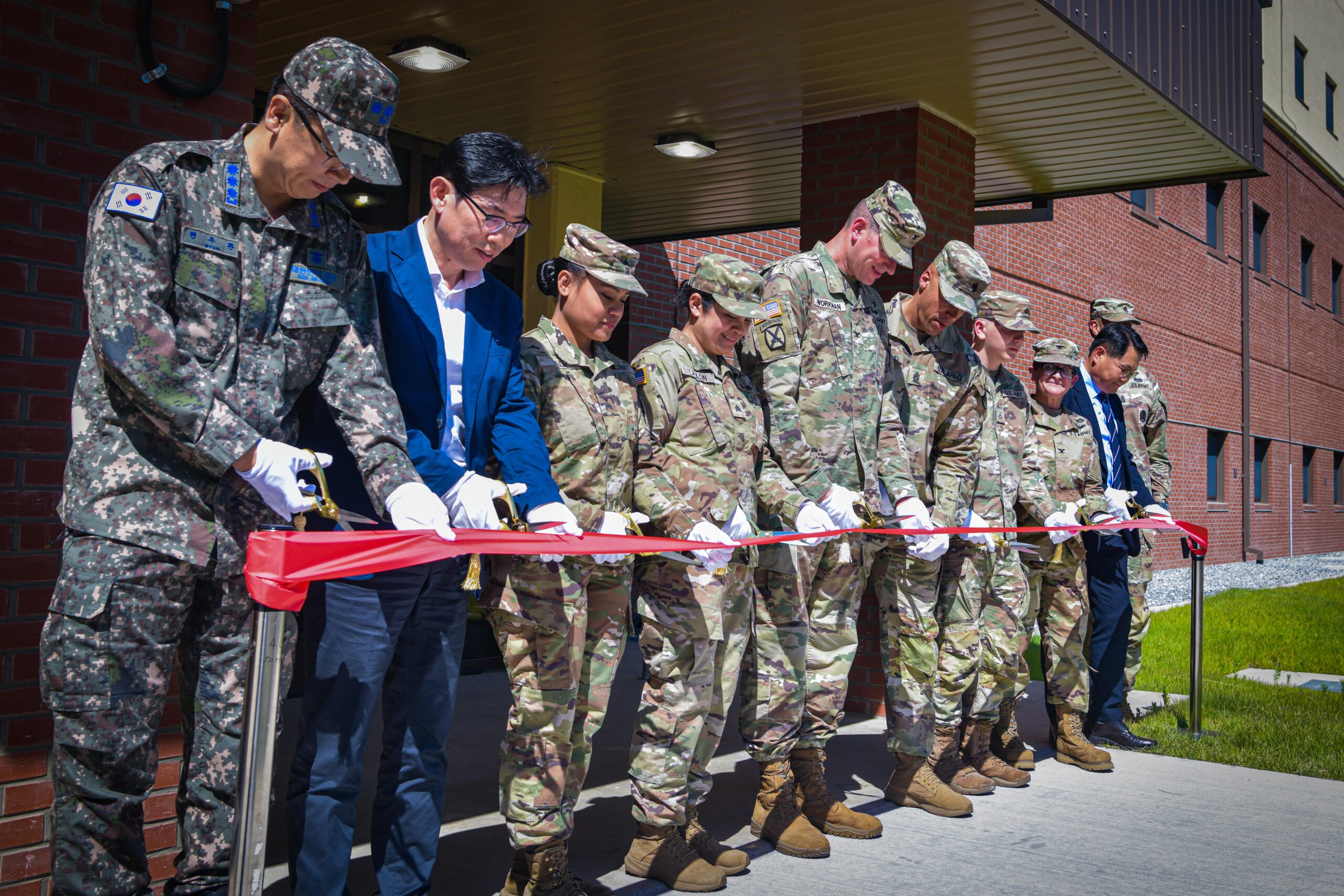 Leadership from U.S. Army Garrison Humphreys, the U.S. Army Corps of Engineers Far East District, and the Korea Ministry of National Defense and their distinguished guests opened new unaccompanied enlisted housing during a ribbon-cutting ceremony May 31, 2024, on Camp Humphreys, South Korea. These housing facilities will allow military personnel to enjoy suite-style living with many included amenities while living on base. (U.S. Army photo by Sgt. Duong Le)