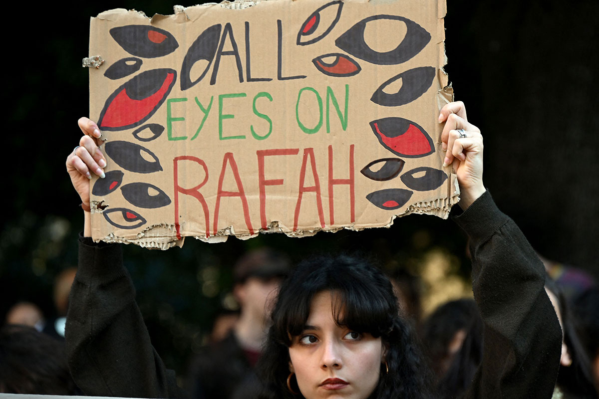 A demonstrator holds up a placard reading 