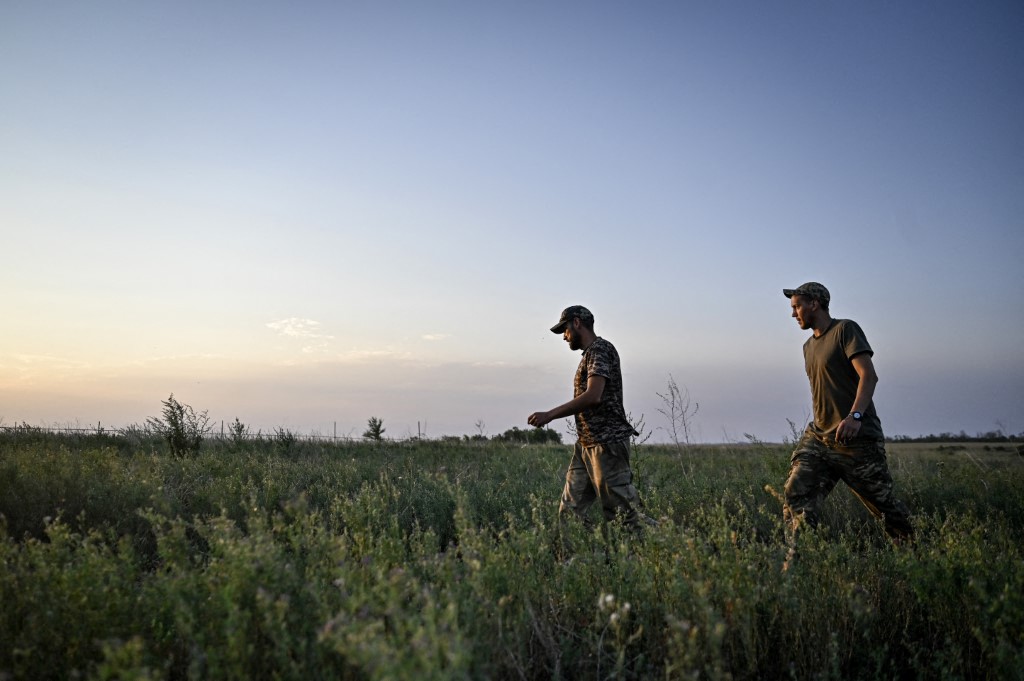 Ukraine's Servicemen of the 24th King Danylo Separate Mechanized Brigade are walking through a field during a combat mission near Chasiv Yar