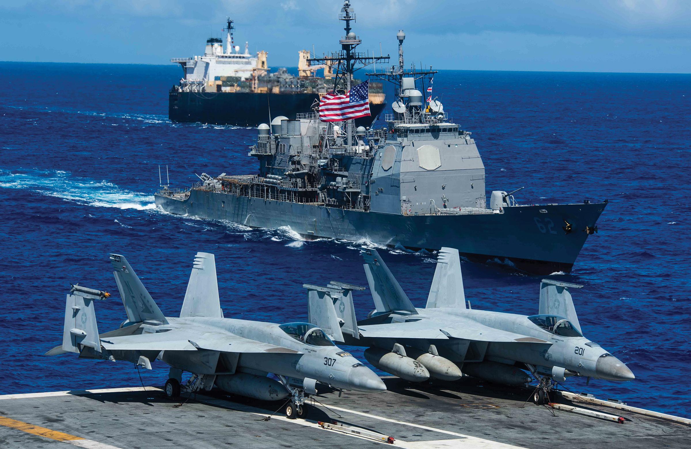 The Ticonderoga-class missile cruiser USS Chancellorsville (CG 62) and USNS 2nd Lt. John P. Bobo (T-AK 3008) steam alongside the Navy’s forward deployed aircraft carrier USS Ronald Reagan (CVN 76) during a photo exercise for Valiant Shield 2018