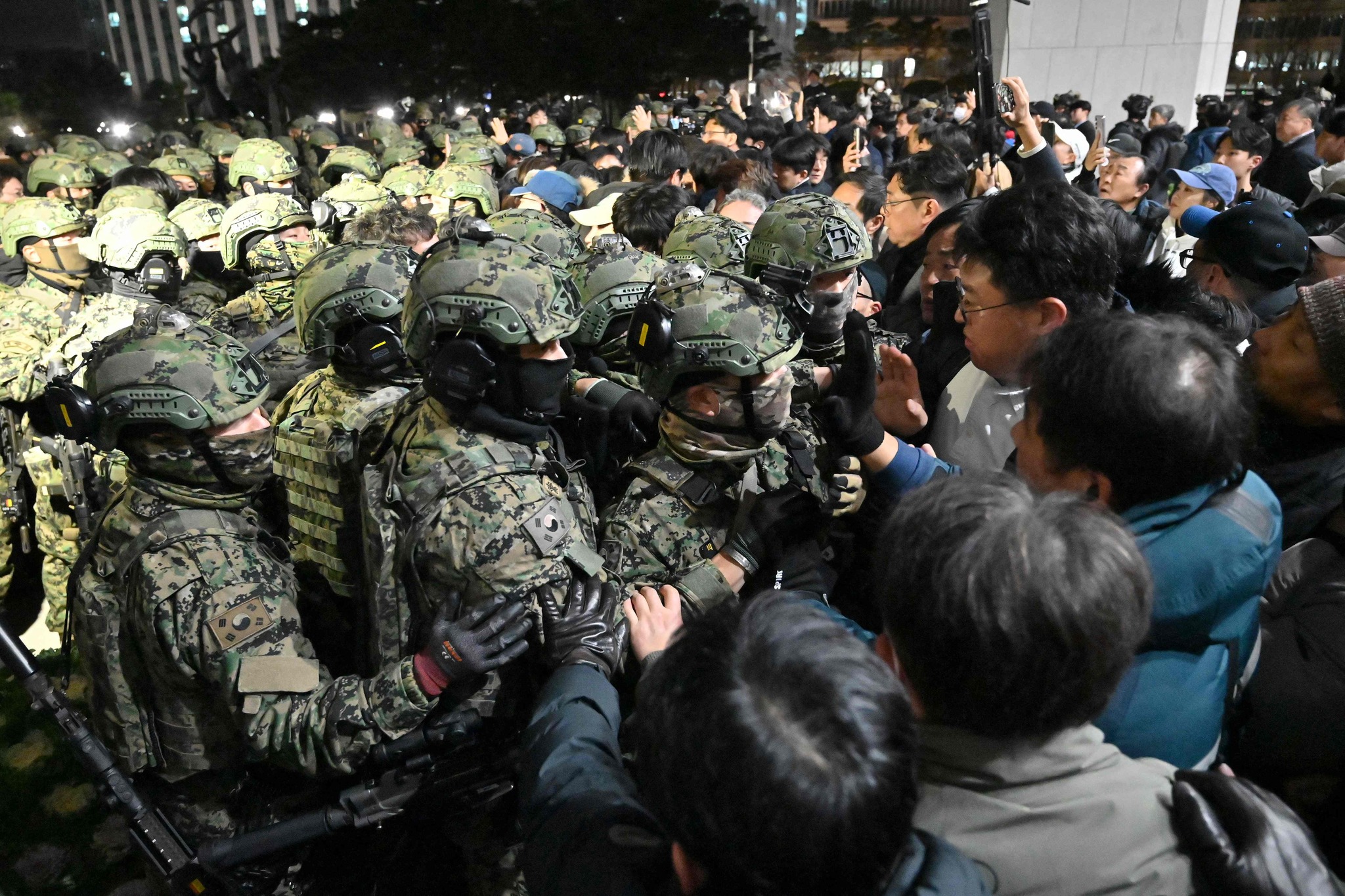 Soldiers try to enter the National Assembly building in Seoul on December 4 2024, after South Korea President Yoon Suk Yeol declared martial law. South Korea's President Yoon Suk Yeol on December 3 declared martial law, accusing the opposition of being 