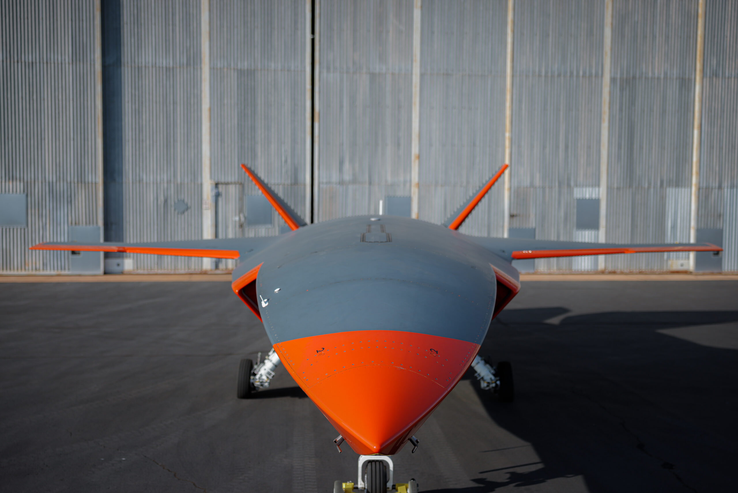 MQ-28A Ghost Bat aircraft in front of a hangar. *** Local Caption *** The first military combat aircraft to be designed, engineered and manufactured in Australia in more than 50 years, the MQ-28A Ghost Bat is an autonomous air vehicle intended to operate as part of an integrated system of crewed and un-crewed aircraft and space-based capabilities.Collaborative combat aircraft (CCA) such as the MQ-28A Ghost Bat are entirely new technology. The aircraft are managed by crewed platforms but have the ability to operate autonomously without continuous control from air or ground-based crews. While the MQ-28A is developmental, continued investment preserves the platform as a sovereign development opportunity that could provide a pathway for potentially accelerated acquisition of a CCA capability in the future.