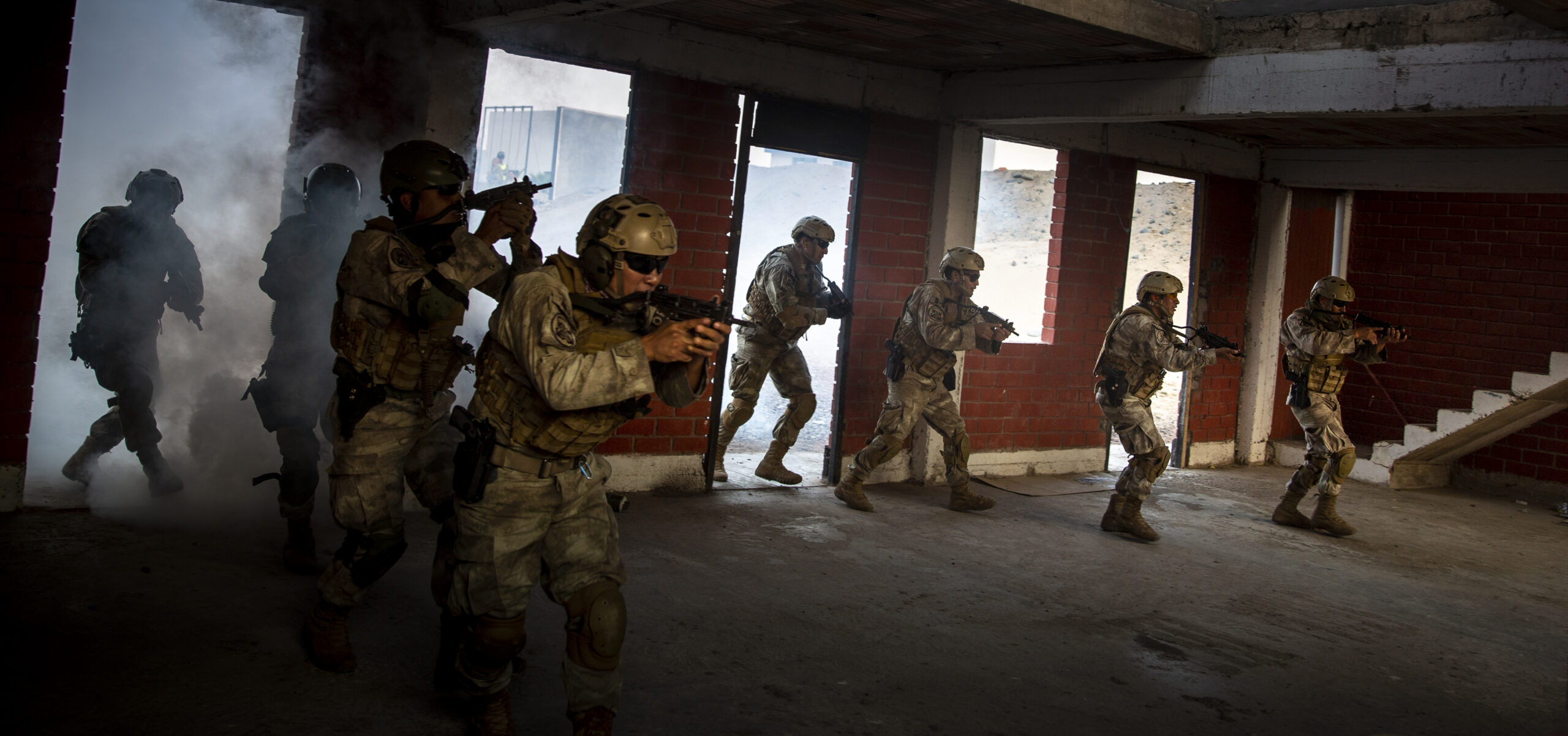 Peruvian commandos make entry into a building during urban operations training as part of exercise Resolute Sentinel 24 at Base Naval De Infanteria De Marina, Lima, Peru, June 6, 2024. The commandos practiced using smoke and flash grenades to mimic close contact engagements in urban combat environments, enhancing their readiness and tactical skills. RS24 is a U.S. Southern Command sponsored exercise that consists of comprehensive joint training opportunities aimed at enhancing regional security and interoperability among the United States, France, Peru, Colombia, Ecuador, Chile, and Brazil. (U.S. Marine Corps photo by Cpl. Samuel Qin)