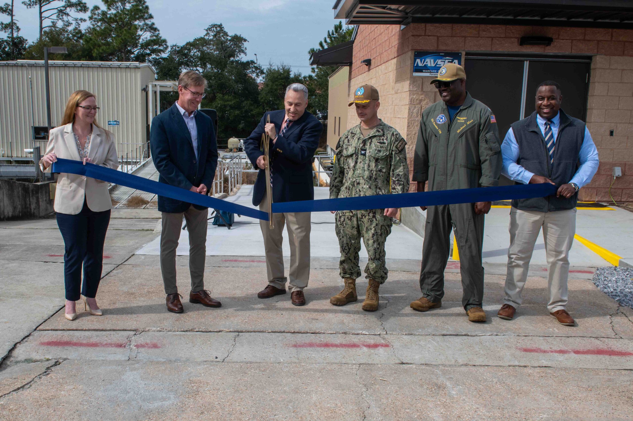 The official party ceremonially open the new Naval Surface Warfare Center Panama City Division Acoustic Test Facility and Instrumentation building onboard Naval Support Activity Panama City, Feb. 5. (from left) Amanda Davis, NSWC PCD (acting) Accounting Division head, Dr. Peter Adair, NSWC PCD technical director, Dr. Joseph Lopes, NSWC PCD Subsea and Seabed Warfare and Maritime Operations Department deputy, Capt. Paul Stence Jr., NSWC PCD commanding officer, Cmdr. Michael Mosi, NSA PC commanding officer, and Dr. Jermaine Kennedy, NSWC PCD Littorals and Undersea Surveillance Division head. (U.S. Navy photo by Eddie Green)