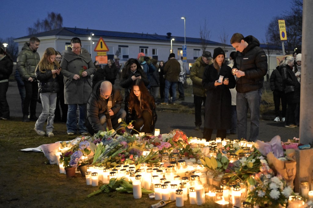 Mourners gather to place flowers and candles outside Risbergska School in Örebro the day after the school shooting in which 11 people lost their lives.