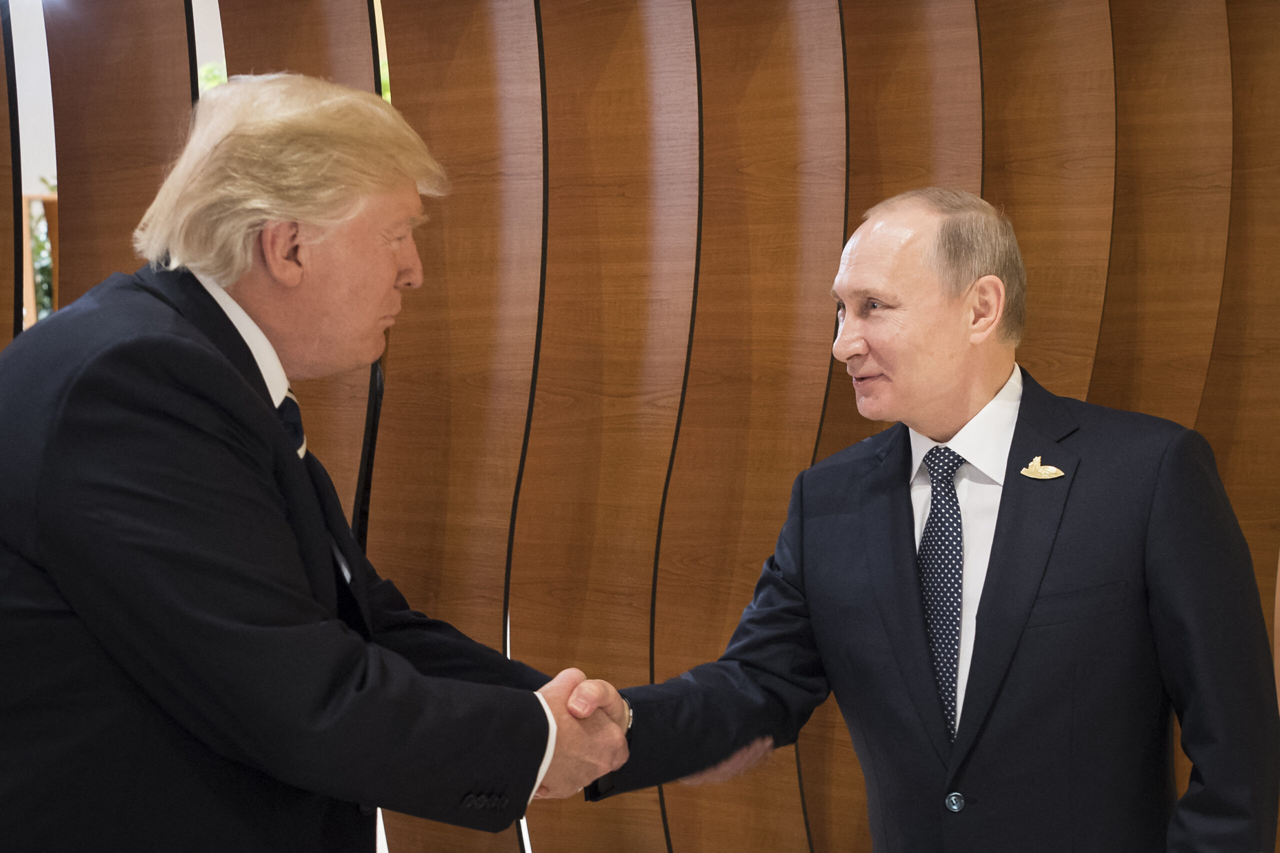 HANDOUT - US-American President Donald Trump (l) and Russian President Vladimir Putin shake hands at the G20 Summit in Hamburg, Germany, 7 July 2017. Photo: Steffen Kugler/Bundespresseamt/dpa (Photo by STEFFEN KUGLER / DPA / dpa Picture-Alliance via AFP)