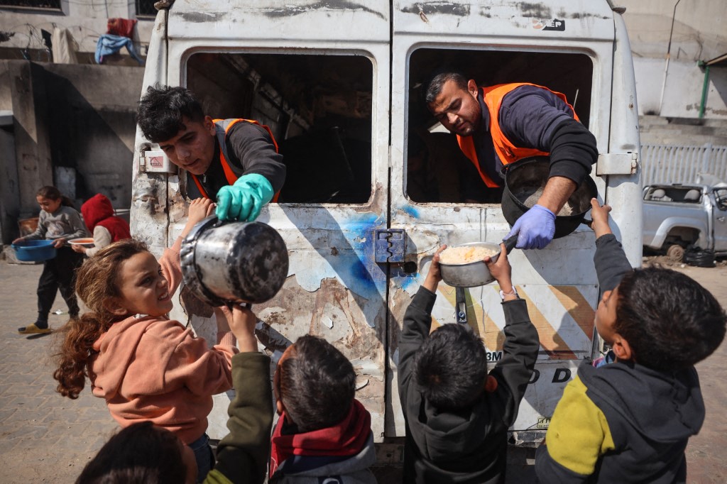 Palestinians gather to receive aid food distributed by charitable hospices in Gaza City, Palestine, on February 14, 2025.