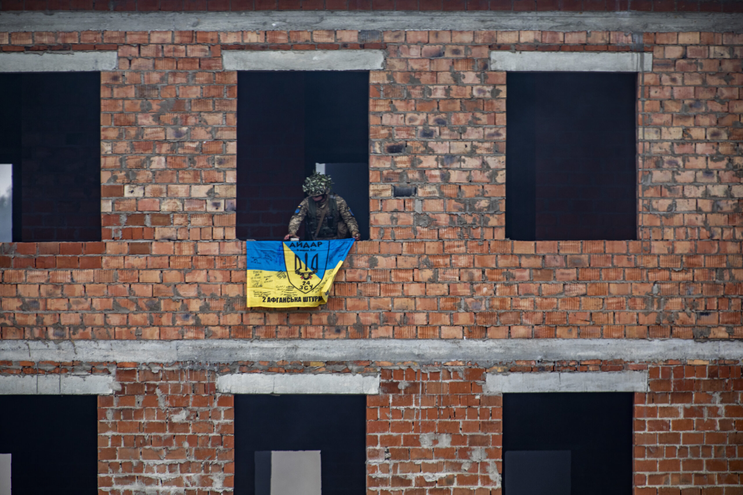 Armed Forces of Ukraine soldier places a Ukrainian flag on the building his unit cleared during urban operation demonstration. This demonstration was for visiting dignitaries from various participating nations. Rapid Trident 2021 involves approximately 6,200 personnel from 12 nations, Sept. 20- Oct. 1, 2021, at the International Peacekeeping Security Centre near Yavoriv, Ukraine. Rapid Trident is an annual, multinational exercise that supports joint combined interoperability among the partner militaries of Ukraine and the United States, as well as Partnership for Peace nations and NATO allies