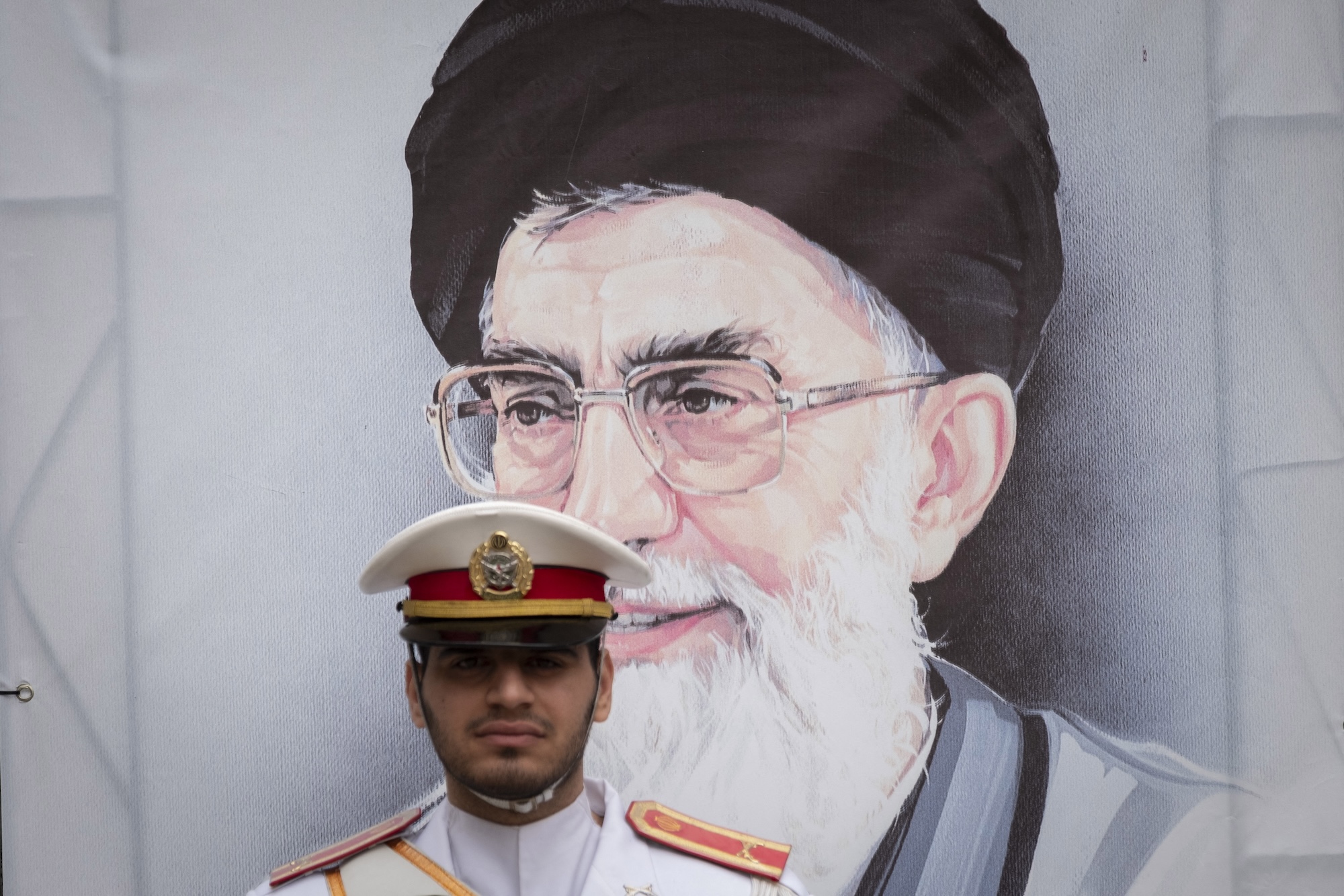 A member of an Iranian Army honor guard stands at attention in front of a portrait of Iran's Supreme Leader, Ayatollah Ali Khamenei, during a ceremony