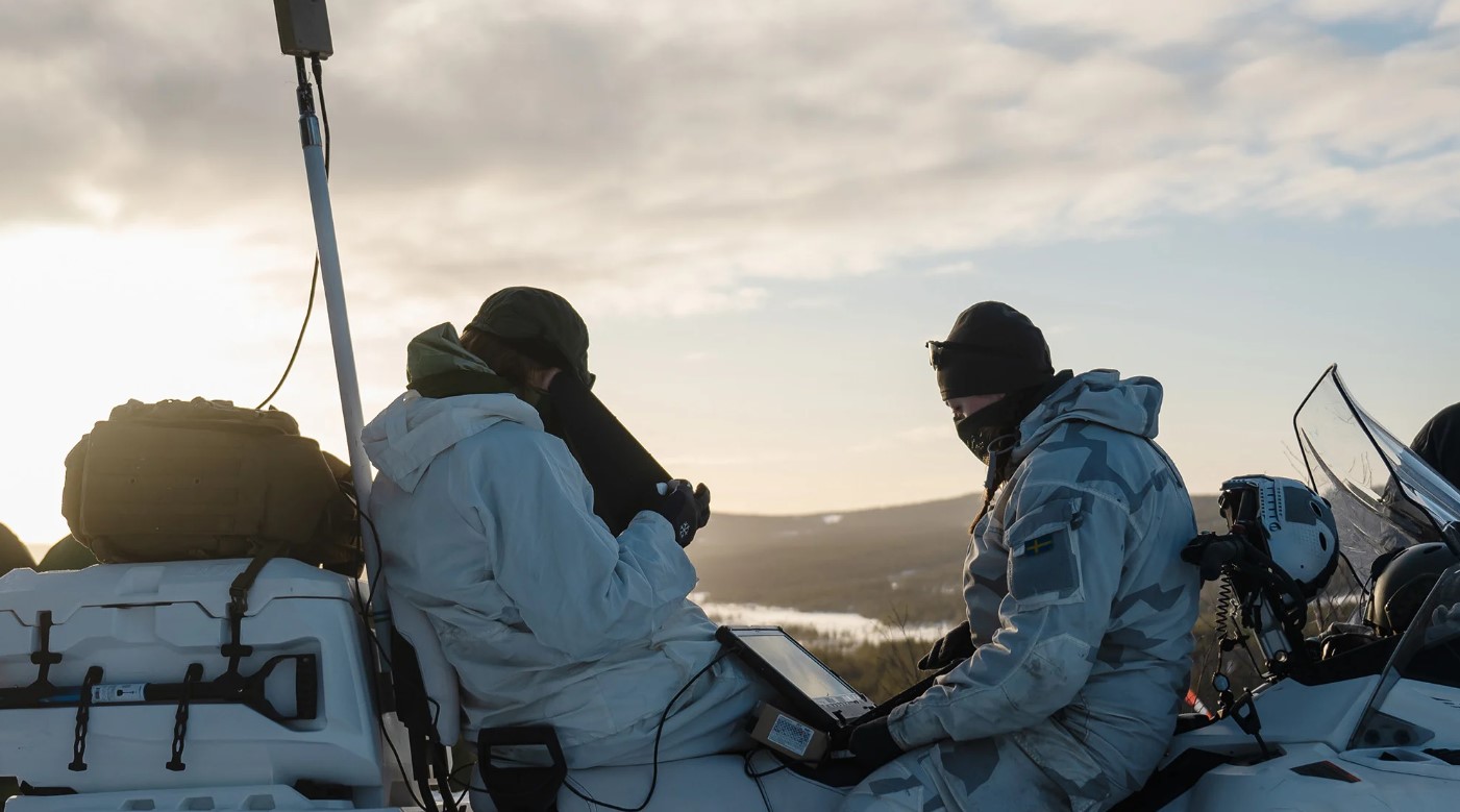 UAV operators on snowmobiles during Arctic strike.