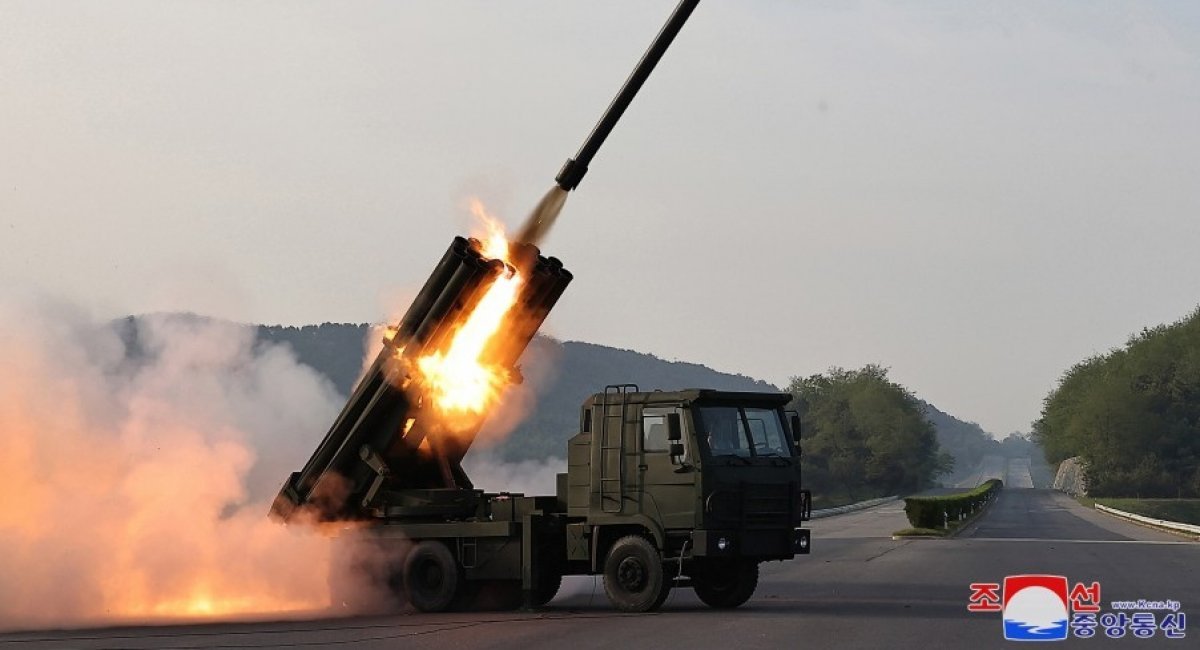 An M1991 Multiple Launch Rocket System (MLRS) is seen launching a rocket from one of its barrels. The launcher is on the back of the unit's truck component.