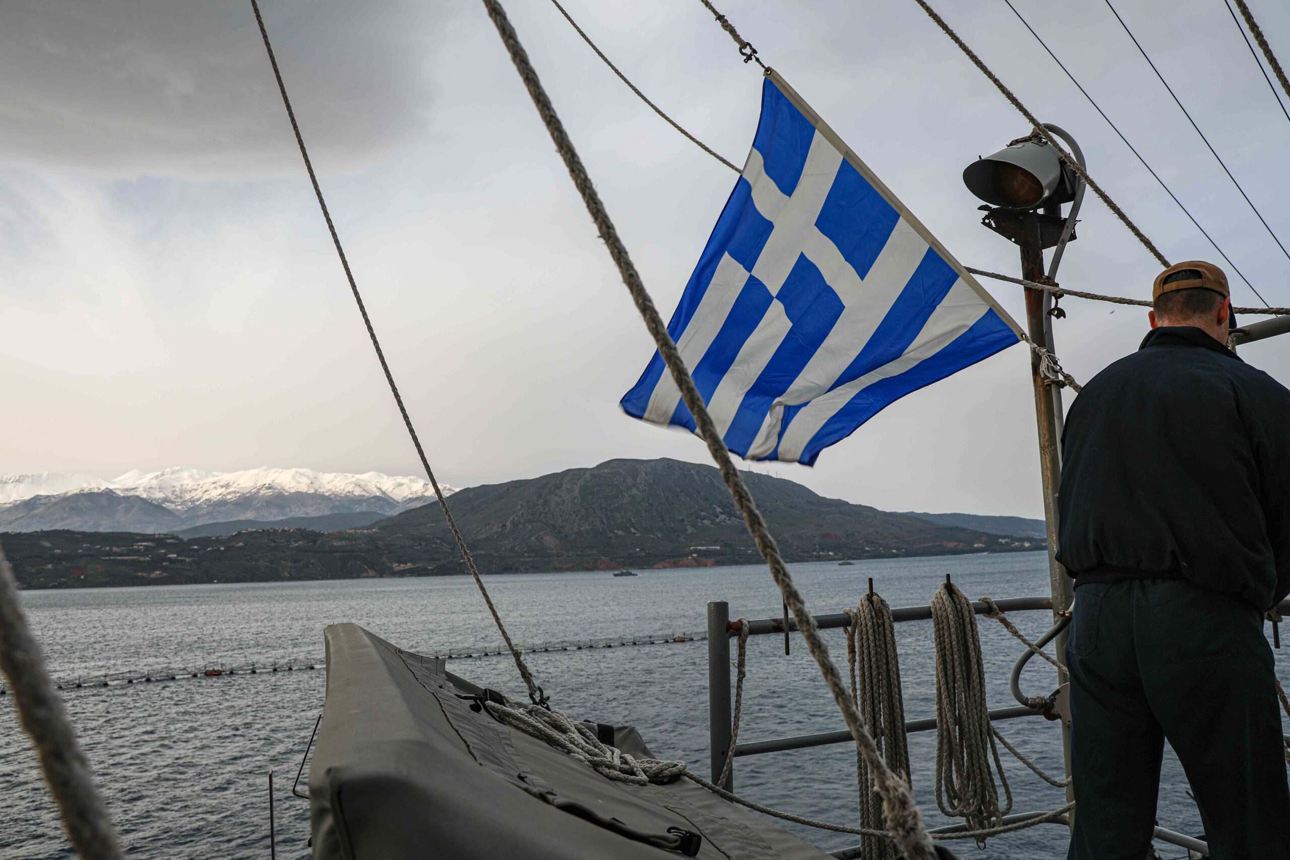 240229-N-ED646-1045 SOUDA BAY, GREECE (Feb. 29, 2024) Quartermaster 1st Class Brandon Gould, assigned to the Harpers Ferry-class dock landing ship USS Carter Hall (LSD 50), hoists up the Greek flag as the ship pulls into Souda Bay, Greece for a scheduled port visit, Feb. 29. Carter Hall is on a scheduled deployment in the U.S. Naval Forces Europe area of operations, employed by the U.S. 6th Fleet to defend U.S., Allied and partner interests. (U.S. Navy photo by Mass Communication Specialist 2nd Class Moises Sandoval)