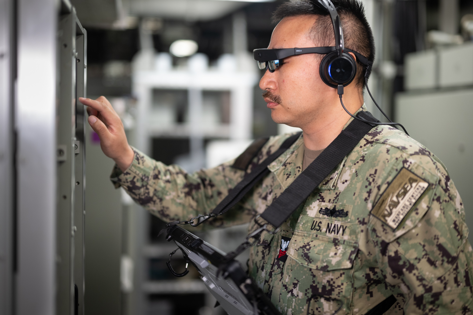 Naval Surface Warfare Center, Port Hueneme Division (NSWC PHD) Fire Controlman Petty Officer 1st Class Donald Tran demonstrates the Augmented Reality Maintenance System aboard USS Spruance (DDG 111) during a recent Combat Systems Assessment Team event at NSWC PHD. The technology could reduce the number of onboard technical assistance visits by connecting sailors and subject matter experts through augmented reality and audio.