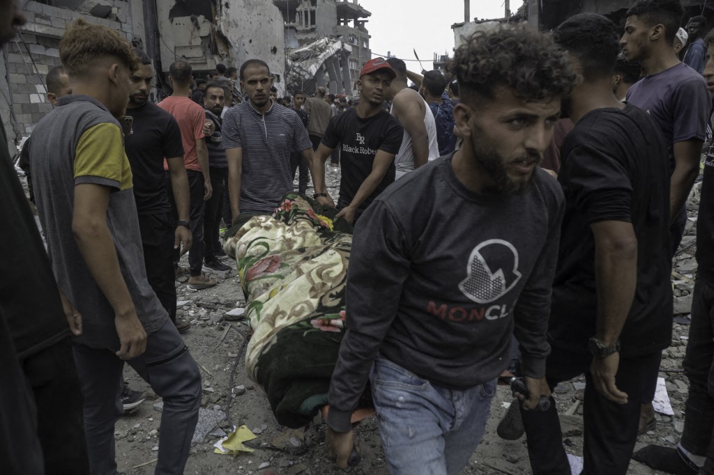 Paramedics and Palestinian people carry the bodies of people killed in Israel's attack on al-Touba (al-Tawbah) Mosque west of Jabalia Camp, north of the Gaza Strip on May 15, 2025.