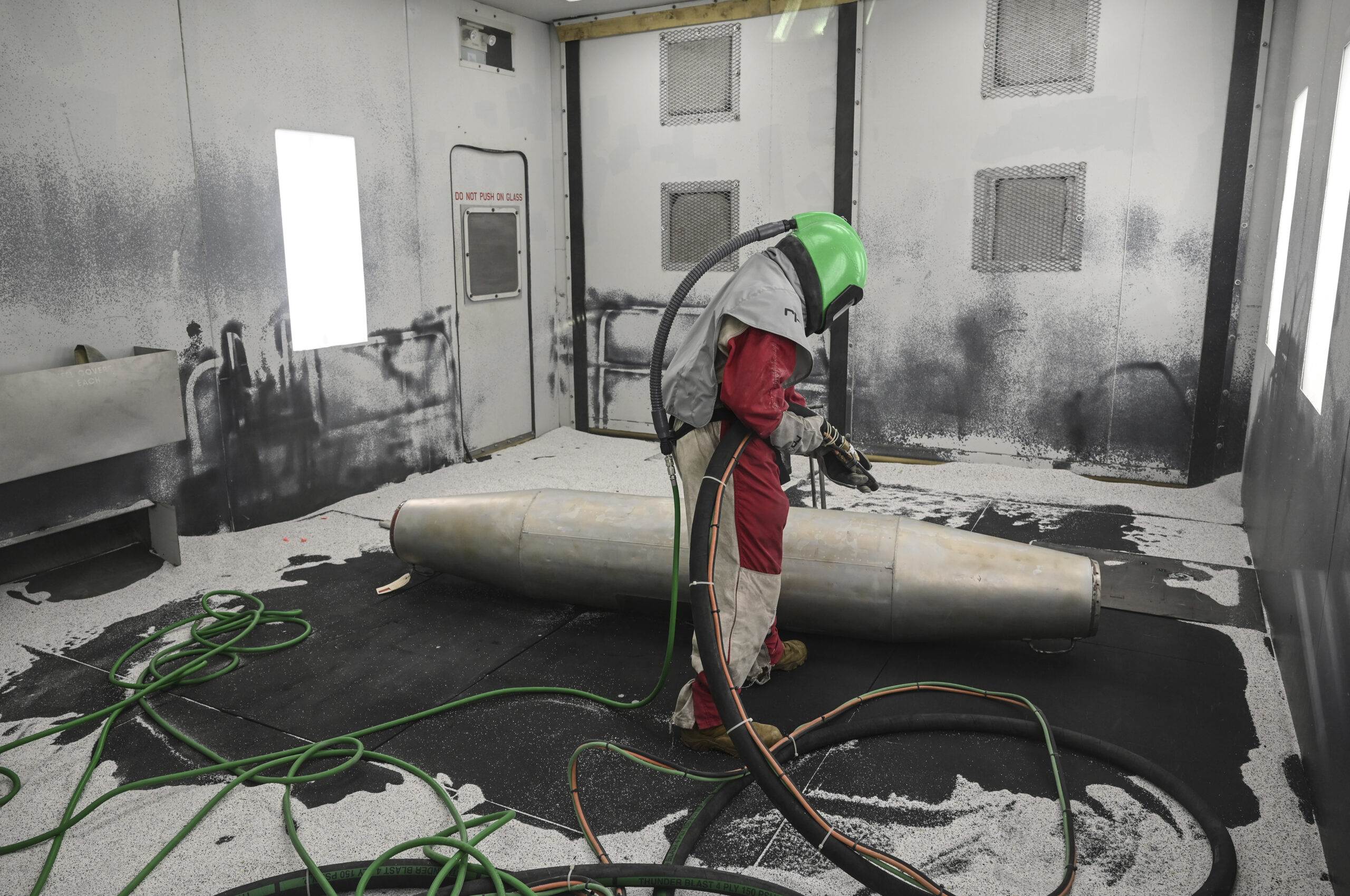 U.S. Air Force Senior Airman Leonard Jacob, 33rd Maintenance Squadron low obersaverables aircraft structural maintenance journeyman, conducts media blasting operations Sept. 13, 2021 at Eglin Air Force Base, Florida. Media blasting operations removes paint and corrosion, allowing the nondestructive inspection shop to inspect the part for damage before it is recoated and painted. (U.S. Air Force photo by Senior Airman Heather LeVeille)