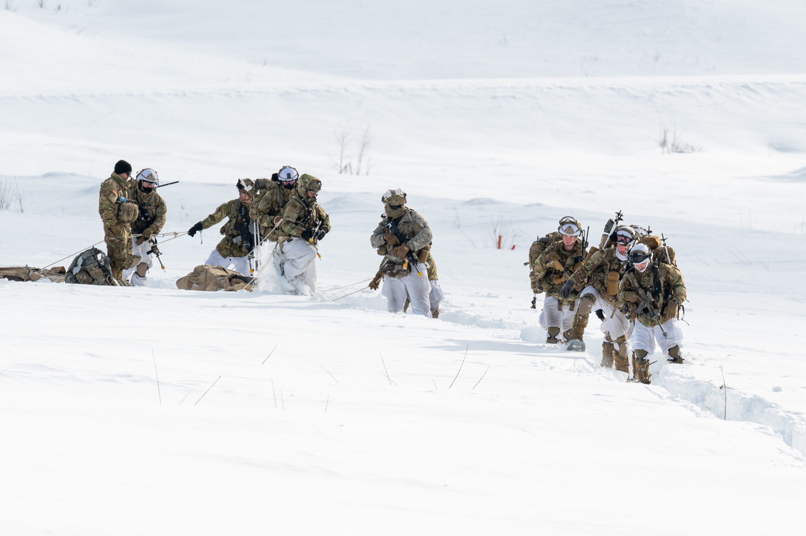 U.S. Army paratroopers assigned to the 3rd Battalion, 509th Parachute Infantry Regiment, 2nd Infantry Brigade Combat Team (Airborne), 11th Airborne Division, move across a snow-filled landing zone during Joint Pacific Multinational Readiness Center-Alaska 23-02 at Yukon Training Area, Ft. Wainwright, Alaska, March 28, 2023. With more than 8,000 participants and observers from 12 different countries, JPMRC-AK 23-02’s multinational environment helps increase Arctic proficiency throughout the Army and the joint force, in support of the nation’s, and the Army’s Arctic strategy. (U.S. Air force photo by Senior Airman Patrick Sullivan)