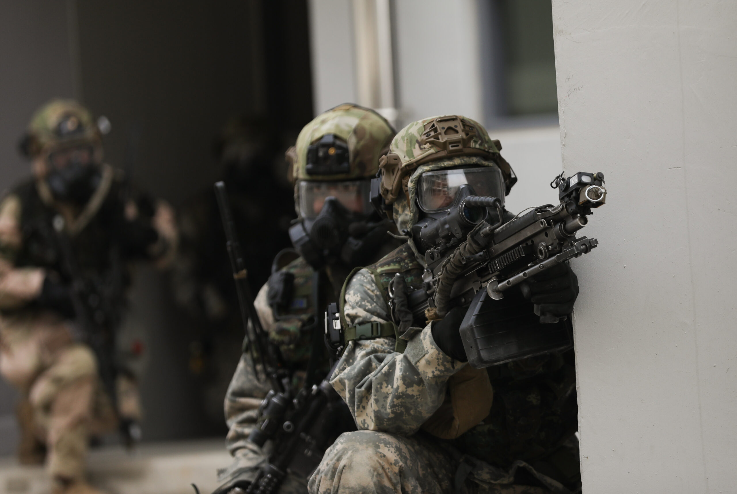 U.S. Army soldier assigned to the 5th Battalion, 20th Infantry Regiment, 1-2nd Stryker Brigade Combat Team, offers covered fire for squad members during a military operation on urban terrain training on March 17, 2025, in South Korea. The exercise focuses on enhancing urban warfare skills, improving coordination, and strengthening interoperability between both forces in complex, close-quarters environments. (U.S. Army photo by Sgt. Oniel McDonald)